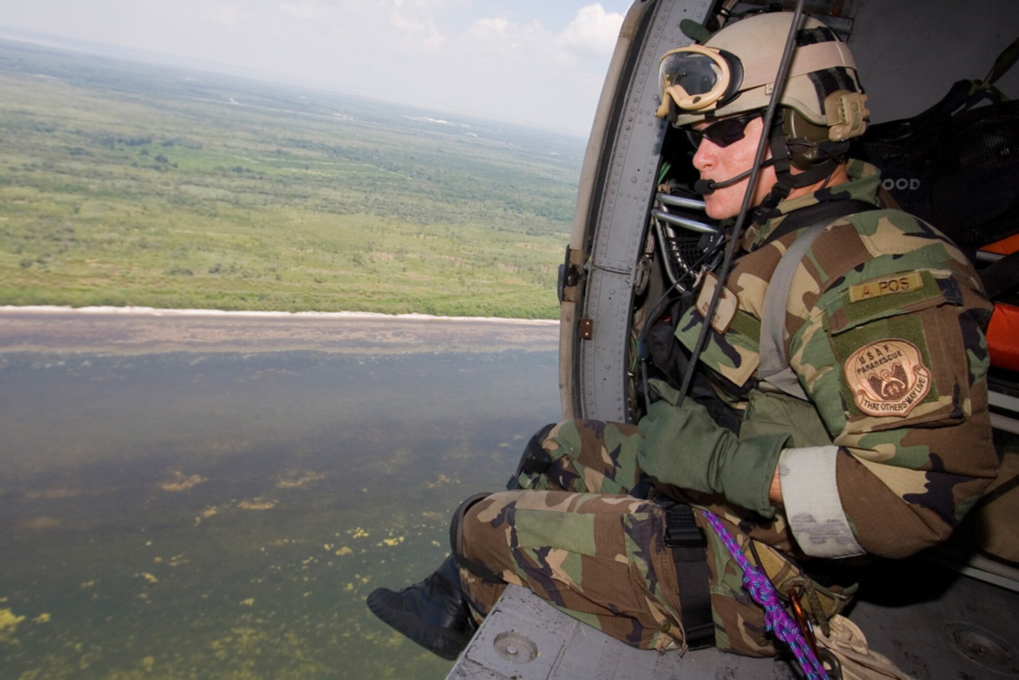 CAPE CANAVERAL AIR FORCE STATION, Fla. -- An Air Force Reserve pararescueman from the 920th Rescue Wing flies aboard an HH-60G Pave Hawk helicopter as part of a ready response team to NASA astronauts .  The reservists are on call during lift off and return of all space shuttle missions.  Moments after the Space Shuttle Discovery's safe return from the International Space Station June 14, Rescue crews head south back to Patrick Air Force Base, Fla. (U.S. Air Force Photo/Tech. Sgt. Jeremy Allen)