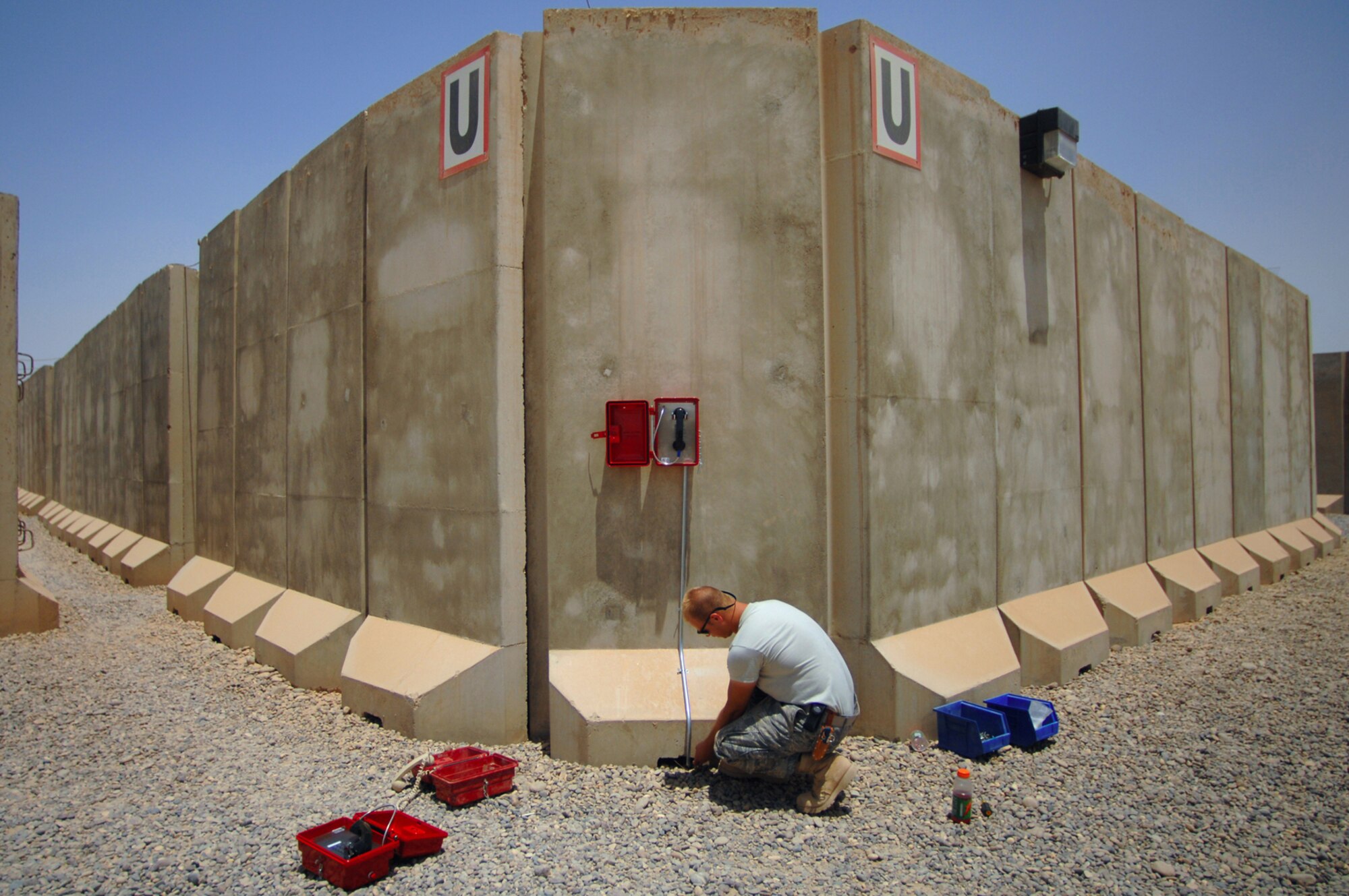 BALAD AIR BASE, Iraq -- Airman 1st Class Marc Spehalski, 332nd Expeditionary Communications Squadron cable dawg, installs a new emergency phone in the Air Force housing area here, June 13. More than 120 lines were installed throughout the area to allow servicemembers to give notice of their whereabouts during accountability checks. Airman Spehalski is deployed from F.E. Warren Air Force Base, Wyo. (U.S. Air Force photo/ Senior Airman Julianne Showalter)