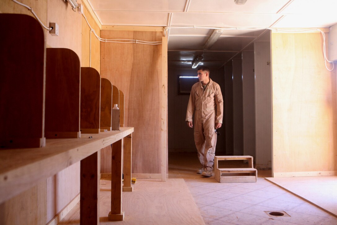 Inspecting the progress of a new phone and internet center, Cpl. Jasques P. Duplantis, 24, a company clerk with Headquarters and Service Company, 2nd Light Armored Reconnaissance Battalion, Regimental Combat Team 5, ensures the work is correct before moving on to the next phase of building at Camp Korean Village, Iraq, June 14. The new center is scheduled to open at the end of June and will provide the Marines and other service members aboard the camp with more than 16 computers and 10 phones to use.
