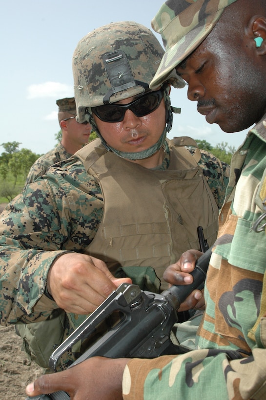 Sgt. Israel Maldonado, Company C, 1st Battalion, 23rd Marine Regiment, shows a Ghanaian infantry soldier how to adjust his rifle sightings during exercise Shared Accord 2008 here June 16. Maldonado, a reservist and Weslaco, Texas resident, was one of almost 300 Marines participating in the exercise that focused not only on infantry training, but supported various humanitarian assistance projects benefiting thousands of Ghanaians and their animals June 10 - 26.