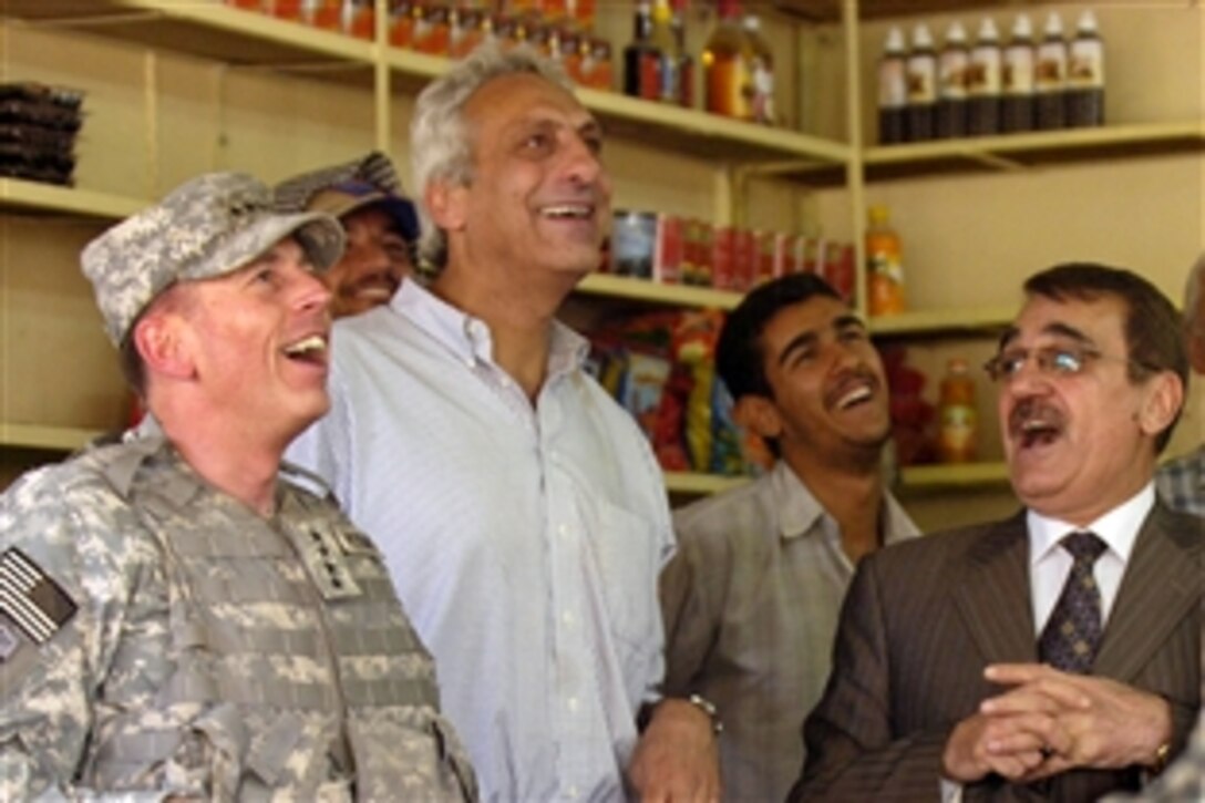 Army Gen. David Petraeus, left, commanding general of Multinational Force Iraq, watches as Iraq scores a goal during a televised soccer match in a shop in Hawijah, Iraq, June 14, 2008. This was Petraeus' first visit to this northeastern city, which has seen a 90 percent drop in violent activity in recent months.