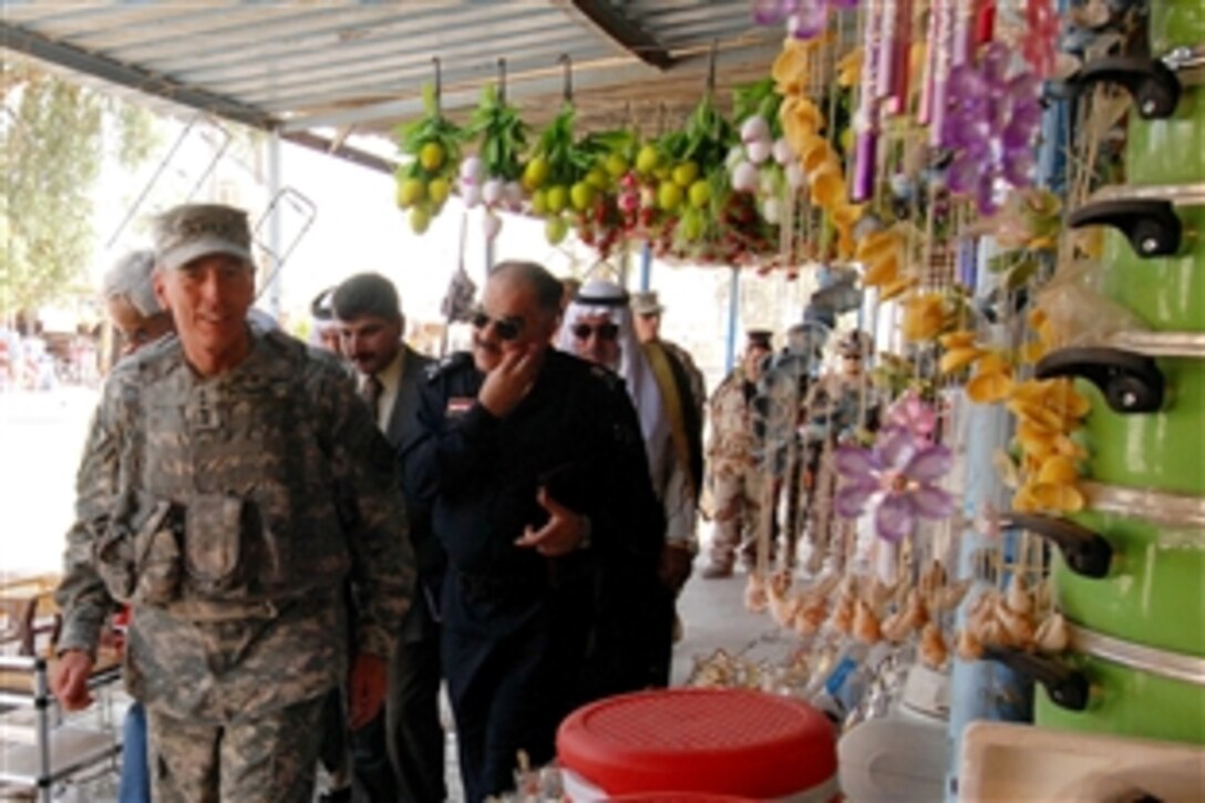 Army Gen. David Petraeus, commanding general of Multinational Force Iraq, walks through a market in downtown Hawijah, Iraq, with Kirkuk provincial leaders and security forces officers during a 'Battle Field Circulation" of northern Iraq, June 14, 2008. This was Petraeus' first visit to this northeastern district in the Kirkuk Province which was once considered the 'Anbar of the North' and has seen around a 90 percent drop in violence since September.