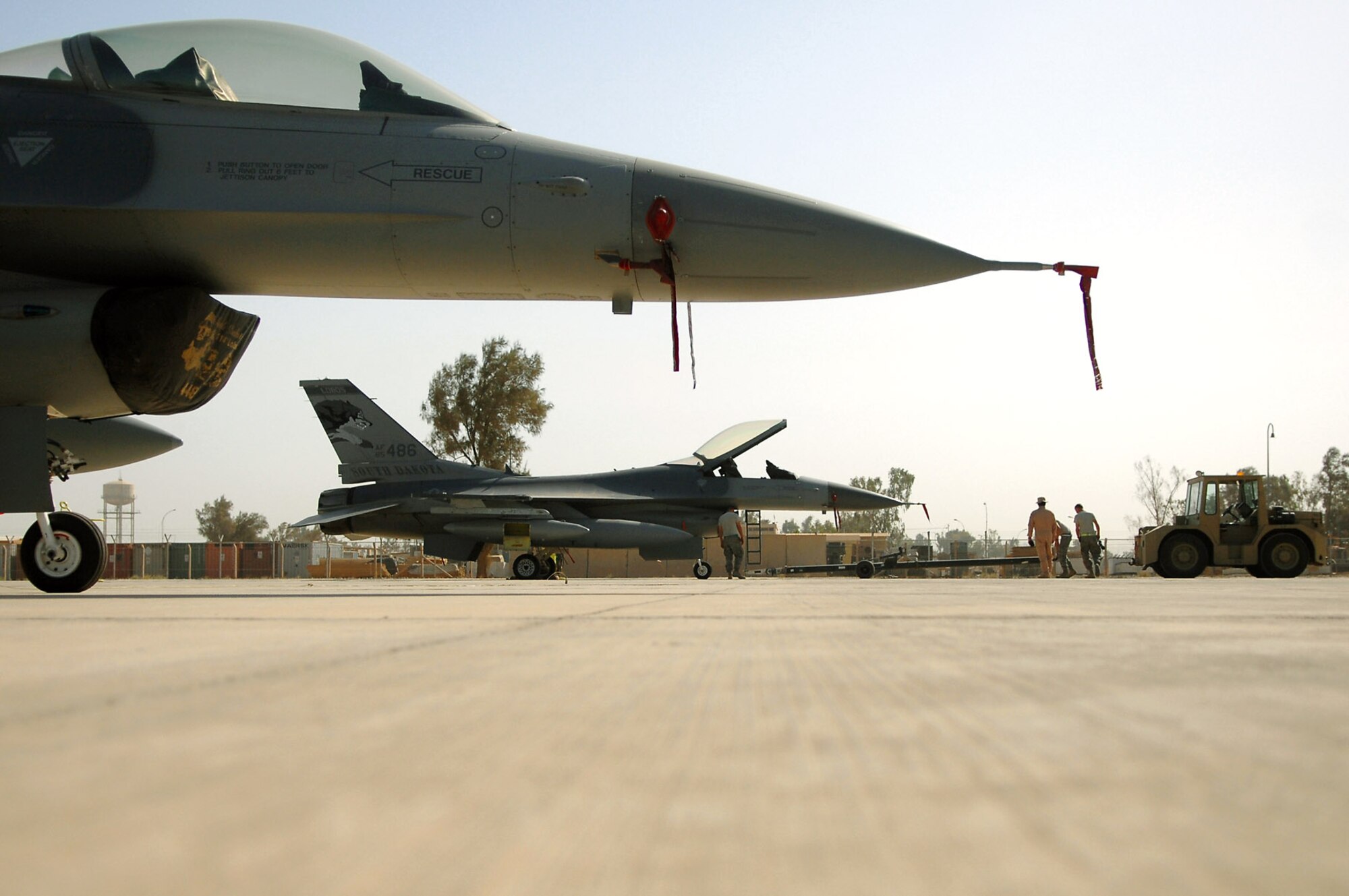 Members of the Iowa and the Wisconsin Air National Guard, assigned to the 332nd Expeditionary Aircraft Maintenance Squadron at Balad Air Base, Iraq, prepare to move F-16 Fighting Falcon aircraft June 13 into hardened shelters.  The aircraft and the personnel from Iowa and Wisconsin Air Guard units are being replaced with aircraft and Airmen from South Dakota and New York ANG units. Rotating fighters helps reduce the amount of time the aircraft are exposed to the hot and dusty weather of Iraq, which can wreak havoc on the planes' components. (U.S. Air Force photo/Senior Airman Julianne Showalter) 