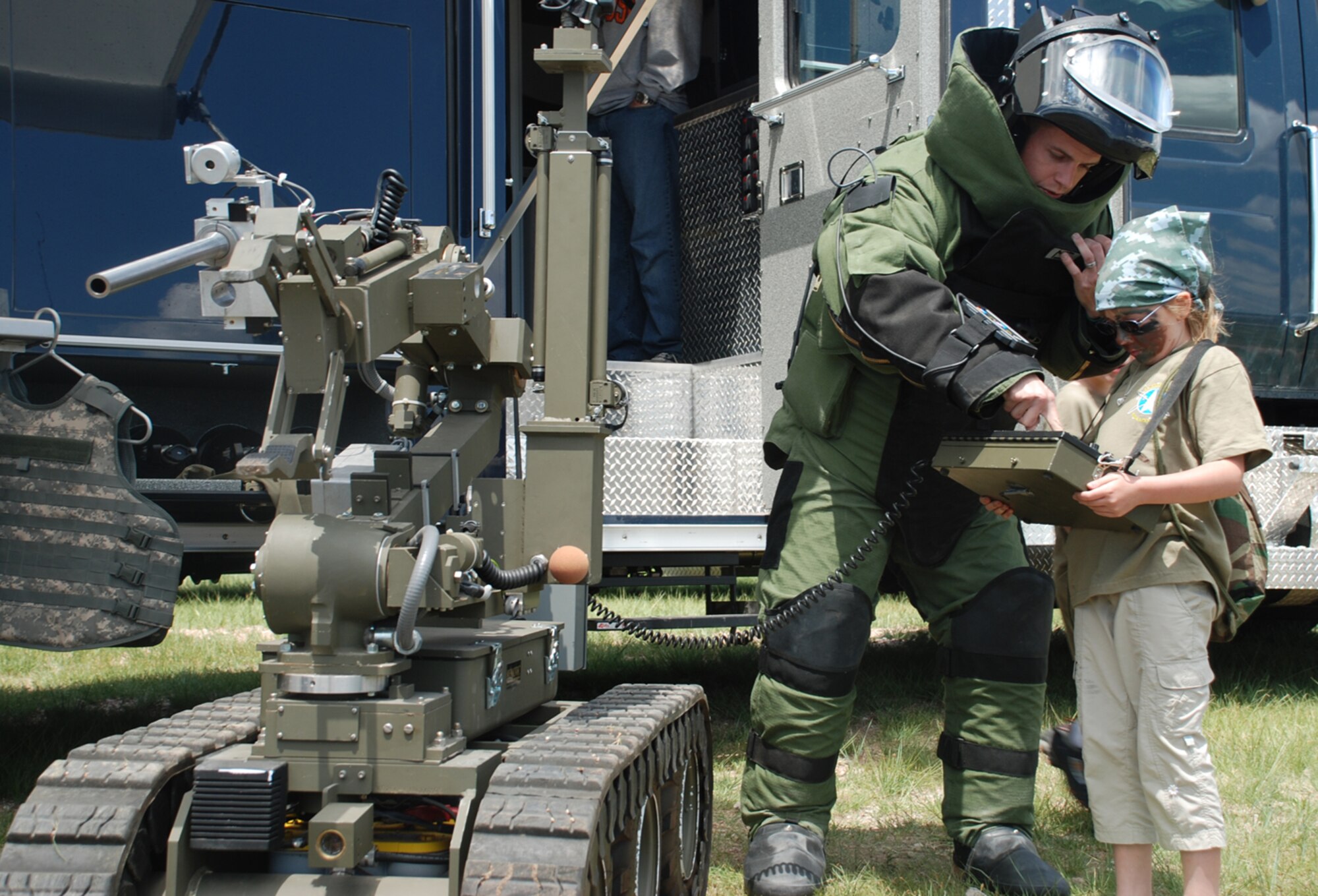 Senior Airman Michael Jamison, 90th Civil Engineer Squadron explosive ordnance disposal flight, allows a Jr. Deployer participant to control the robotic system, “Wolverine,” in Fewastan, a mock base for the Special Processing, Authorization and Combat Effectiveness Jr. Deployer Saturday. The event was intended to give children a better idea of what their parents’ deployments are like (Photos by Airman 1st Class Alex Martinez).