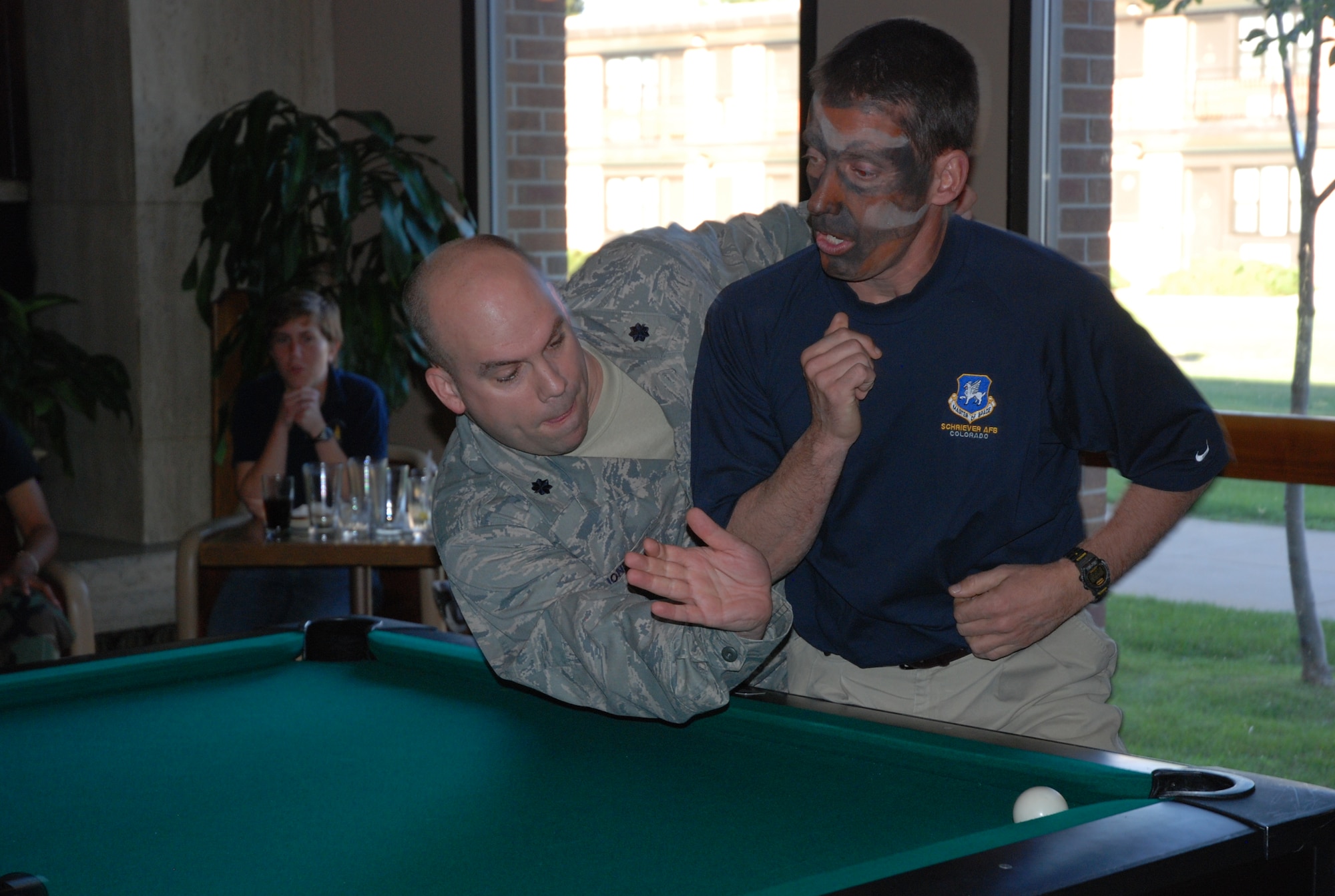 Lt. Col Craig Biondo, 21st Mission Support Group commander, forces his way into shooting position against to physical protest of Col. Robert Skinner, 50th Network Operations Group commander, during the final round of the June 13 CRUD tournament at the Peterson Air Force Base Club in Colorado. The 50th Space Wing defended their CRUD title by holding onto the coveted trophy. (Air Force photo/2nd Lt. Jonathan Simmons)