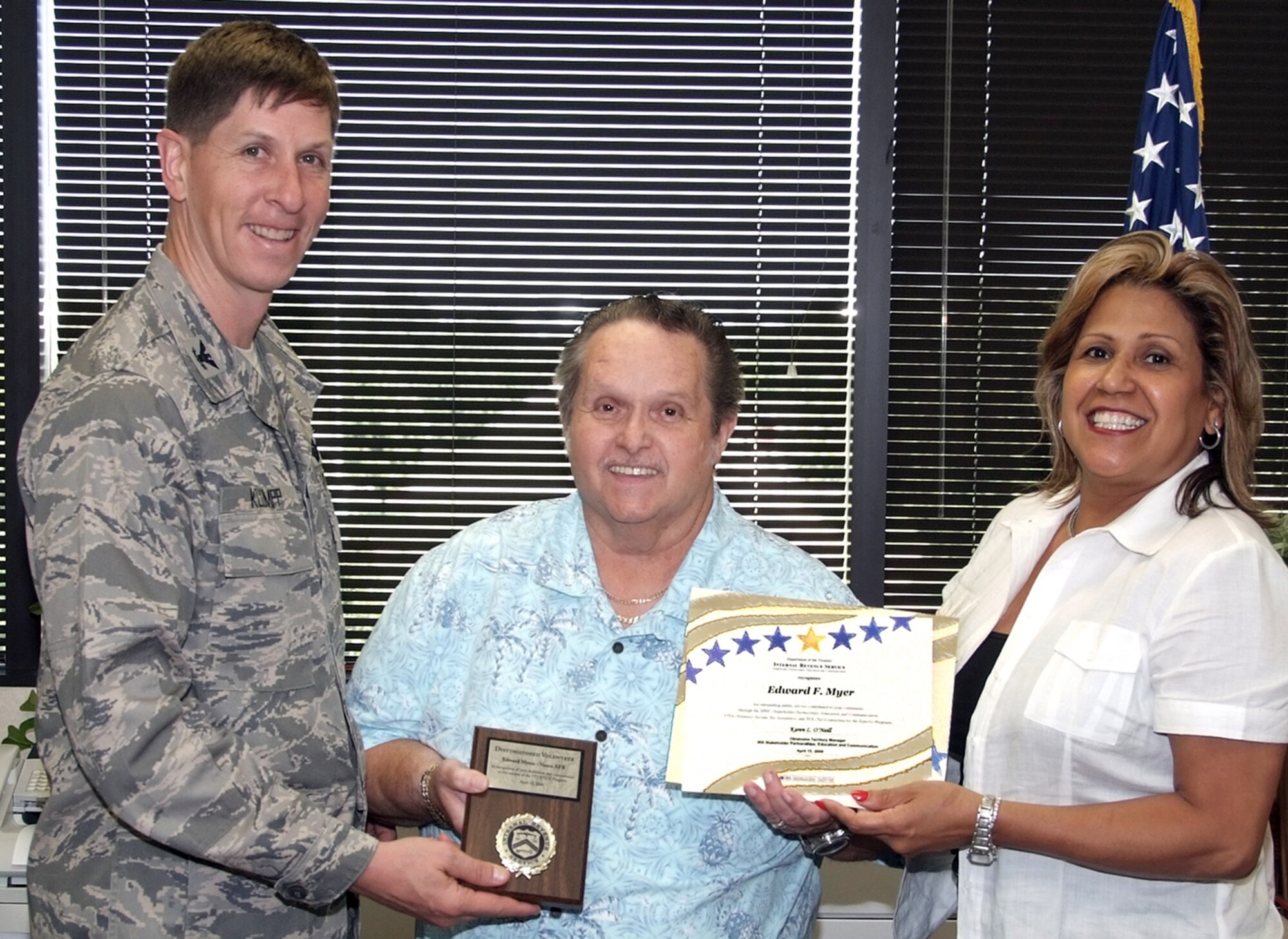 Ed Myer, center, with the 71st Force Support Squadron, receives a plaque from Col. Richard A. Klumpp Jr., 71st Flying Training Wing commander, and Internal Revenue Service representative, Walkidia Gomez. The plaque, presented June 12, recognizes Mr. Myer's outstanding job managing the Vance AFB 2007 tax program. The combined efforts of Mr. Myer and other Volunteer Income Tax Assistance representatives enabled 266 tax clients to have their taxes prepared at a cost savings of $65,646 and total federal refunds of $458,822. (U.S. Air Force photo by Terry Wasson)  