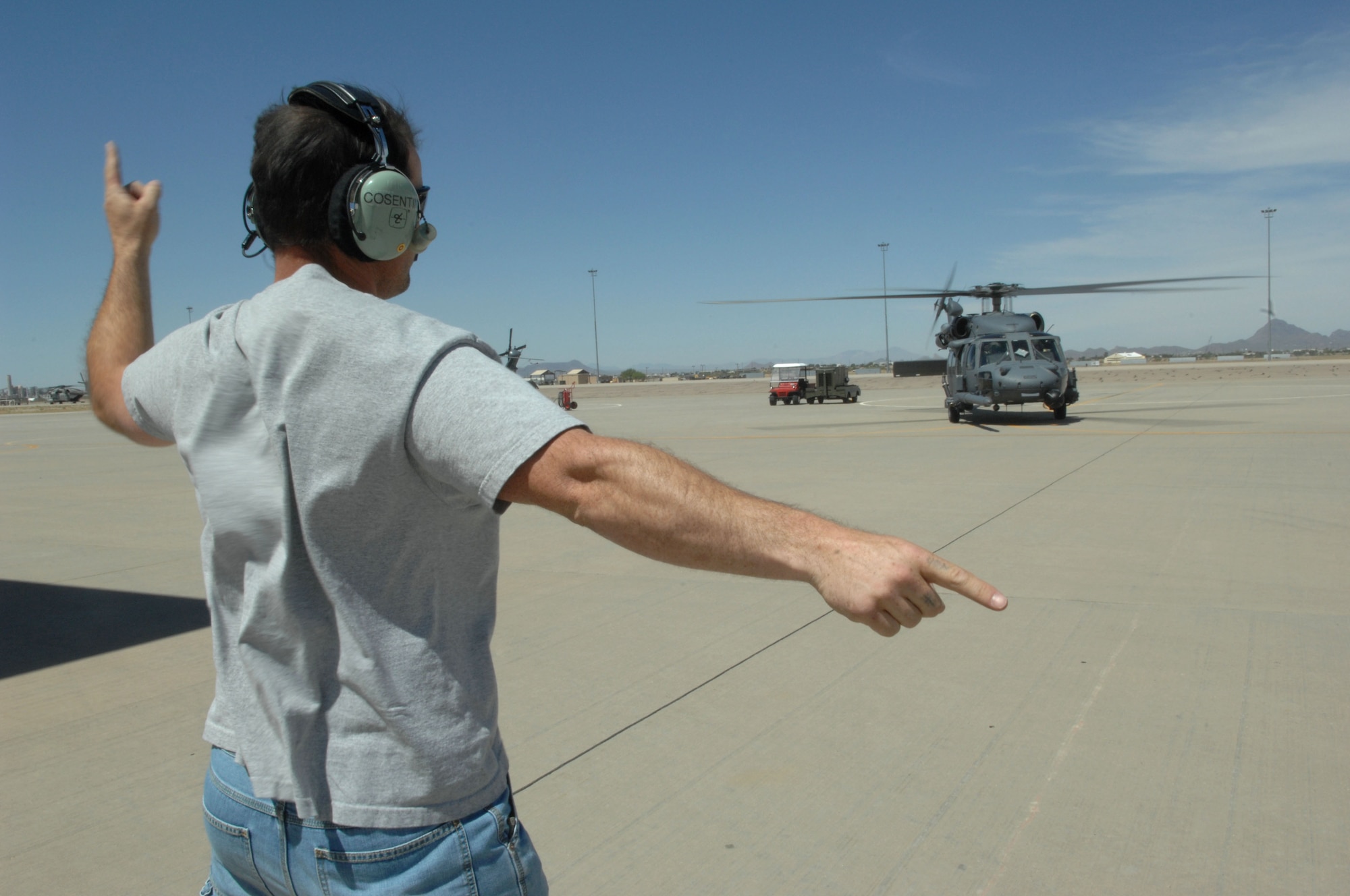Mr. Cosimo Cosentino marshals an HH-60G Pavehawk out of its parking spot for a local tactical training flight.  Mr. Cosentino is assigned as a HH-60 Crew Chief in the 943d Maintenance Squadron and has been with the unit since 2003.  (U.S. Air Force photo by Senior Airman Alesia Goosic) 
