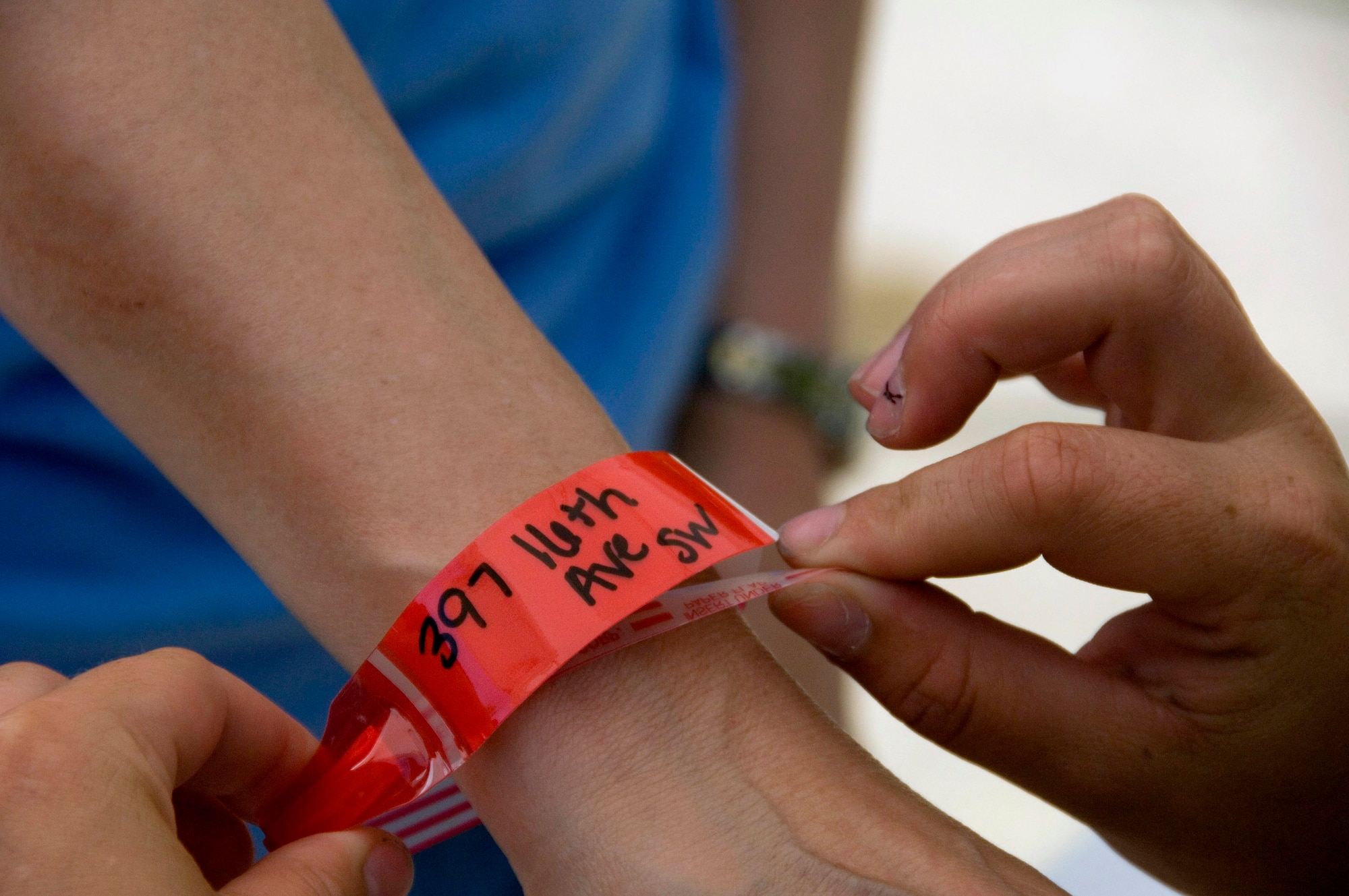 Cedar Rapids, Iowa, residents receiving approval to return to their homes are given a colored wristband to identify them. Residents are allowed to return to their homes during designated times to recover personal items and valuables. (U.S. Air Force photo/Master Sgt. Jack Braden) 
