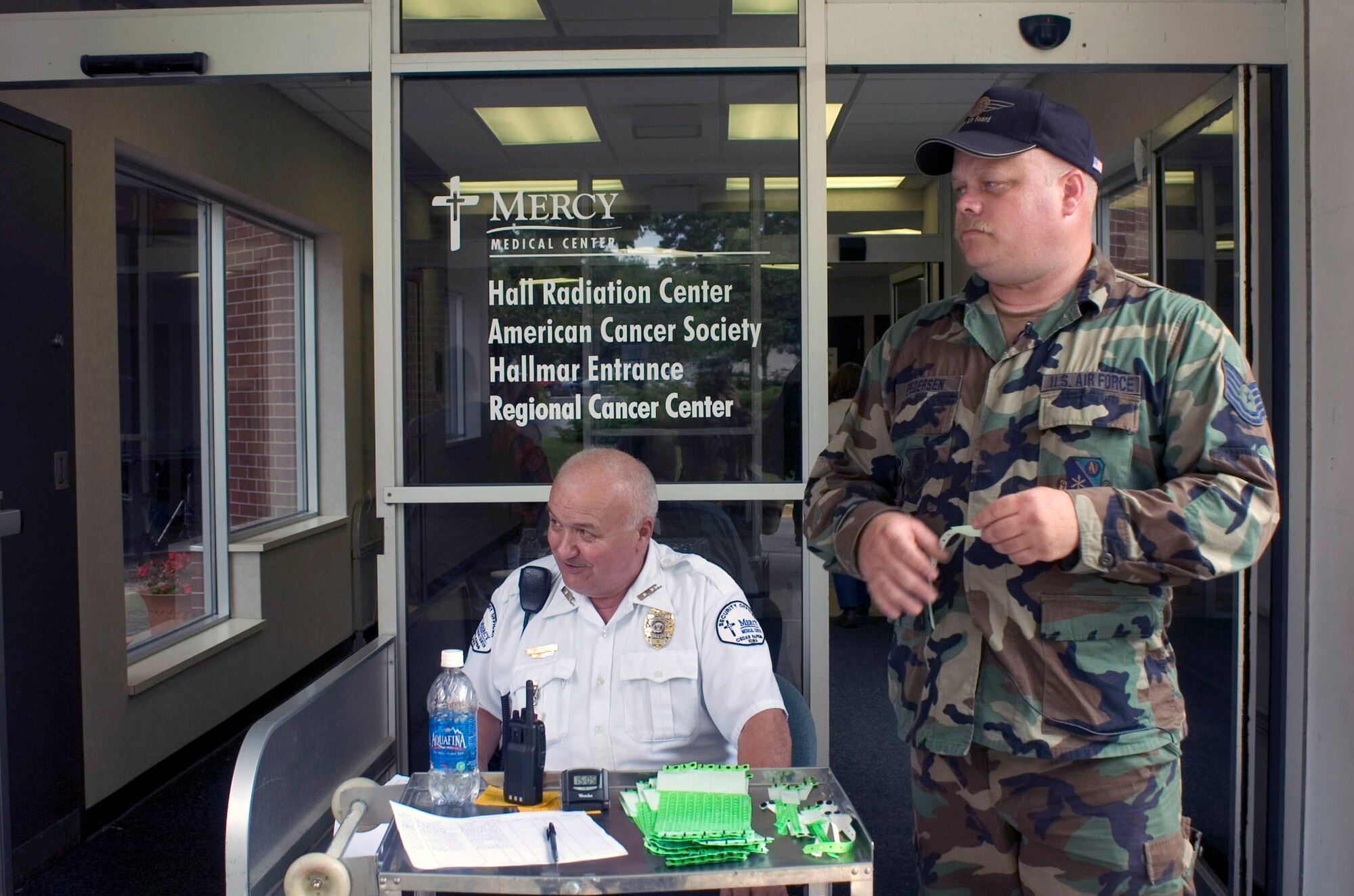Tech. Sgt. Gregg Pedersen stands post outside the Mercy Medical Center in Cedar Rapids, Iowa, June 15. Sergeant Pedersen checks employees into the hospital by having workers sign in and wear a green wristband indicating they were cleared through a checkpoint. More than 150 Airmen arrived in Cedar Rapids today to help secure and recover areas that were affected by flood waters. Sergeant Pedersen is assigned to the 185th Air Refueling Wing located in Sioux City, Iowa. (U.S. Air Force photo/Staff Sgt. Desiree N. Palacios) 
