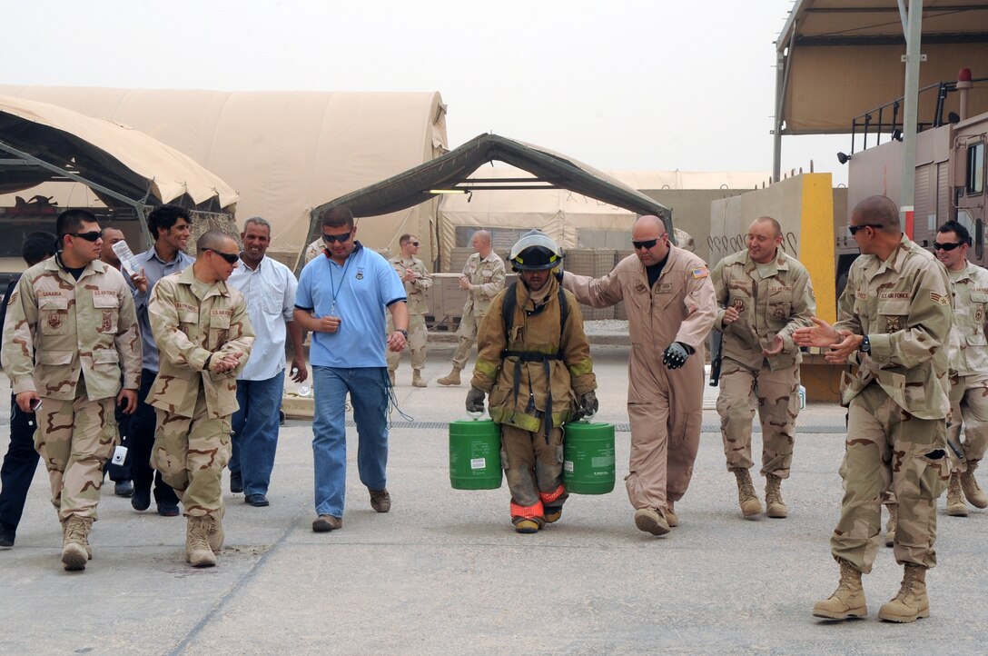 ALI BASE, Iraq -- 407th Expeditionary Civil Engineer Squadron firefighters, cheer on an Iraqi firefighter during the "firefighter challenge" here June 16. The Air Force firefighters provide reoccurring training to local Iraqi firefighters helping them better serve their communities. The Iraqis had to pass the challenge in under eight minutes to graduate the Basic Firefighter Skills Course, the firefighter had to carry two buckets 100 feet. (U.S. Air Force photo/Tech. Sgt. Sabrina Johnson)