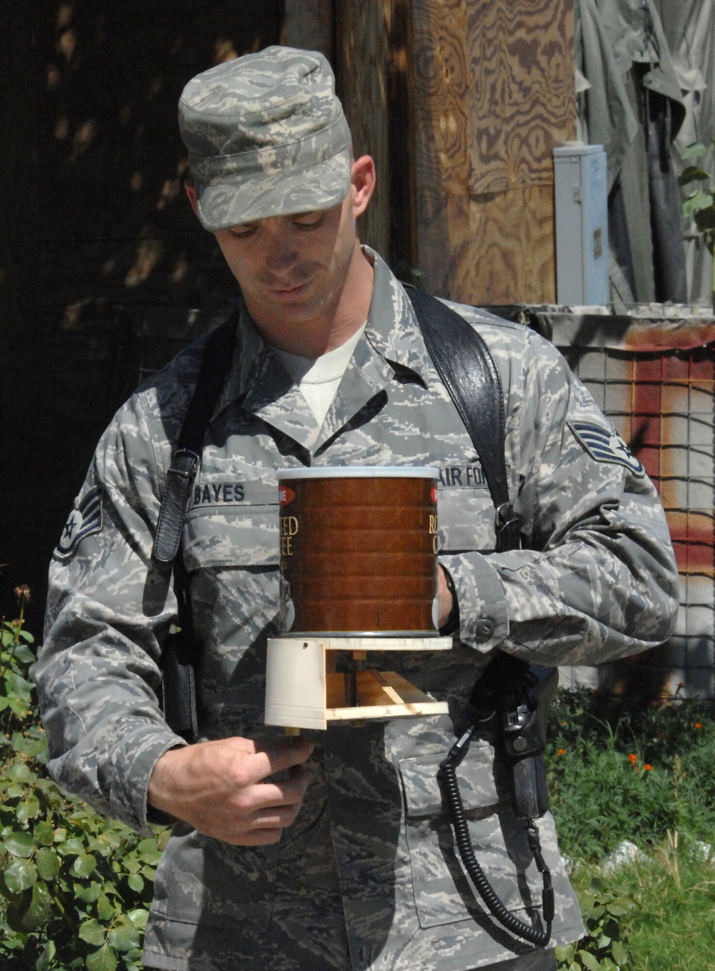 Staff Sgt. Tim Bayes demonstrates how to use a fertilizer spreader he designed and built for use by Afghan farmers. The spreader will potentially help increase crops by 15 to 20 percent annually. Sergeant Bayes is deployed from the Naval Construction Training Center in Gulfport, Miss., and is the Laghman Provincial Reconstruction Team Engineering NCO in charge. (U.S. Air Force photo/Master Sgt. James Law) 