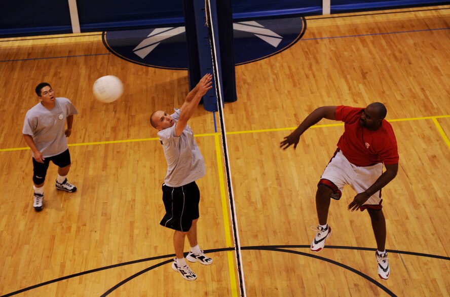 MOODY AIR FORCE BASE, Ga. -- Staff Sgt. Dontavion Smith, 23rd Force Support Squadron volleyball team member, spikes the ball while Staff Sgt. Darick Butman and Tech. Sgt. Eugene Quigley, 723rd Aircraft Maintenance Unit volleyball team members, try to block the ball during the base intramural championship here June 11. (U.S. Air Force photo by Senior Airman Gina Chiaverotti)
