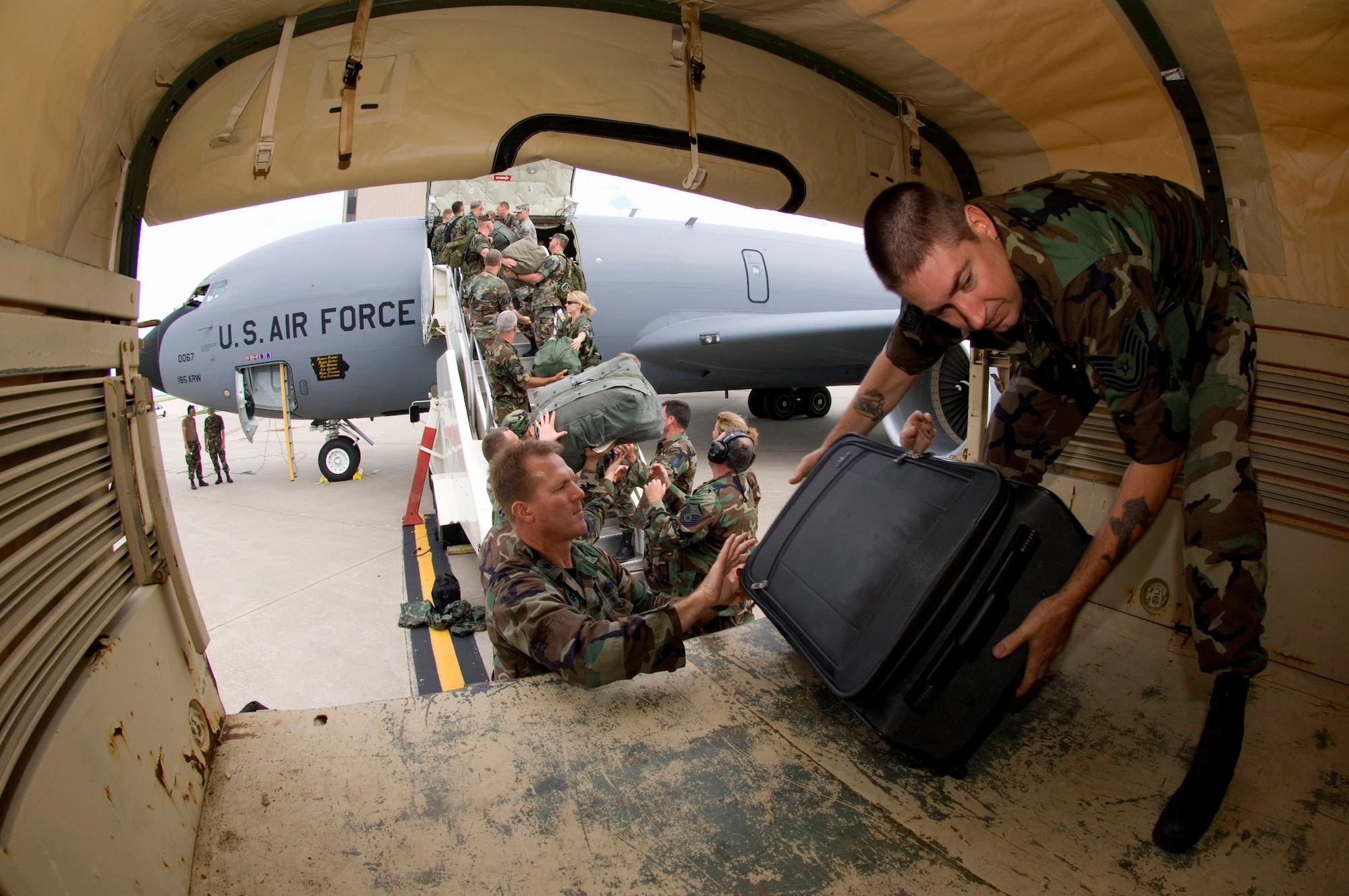 Members of the Iowa Air National Guard's 185th Air Refueling Wing unload their gear at the Eastern Iowa Airport in Cedar Rapids, Iowa. State officials activated the National Guard to the help with recovery efforts after massive flooding caused evacuations from towns along major rivers. (U.S. Air Force photo/Master Sgt. Jack Braden) 