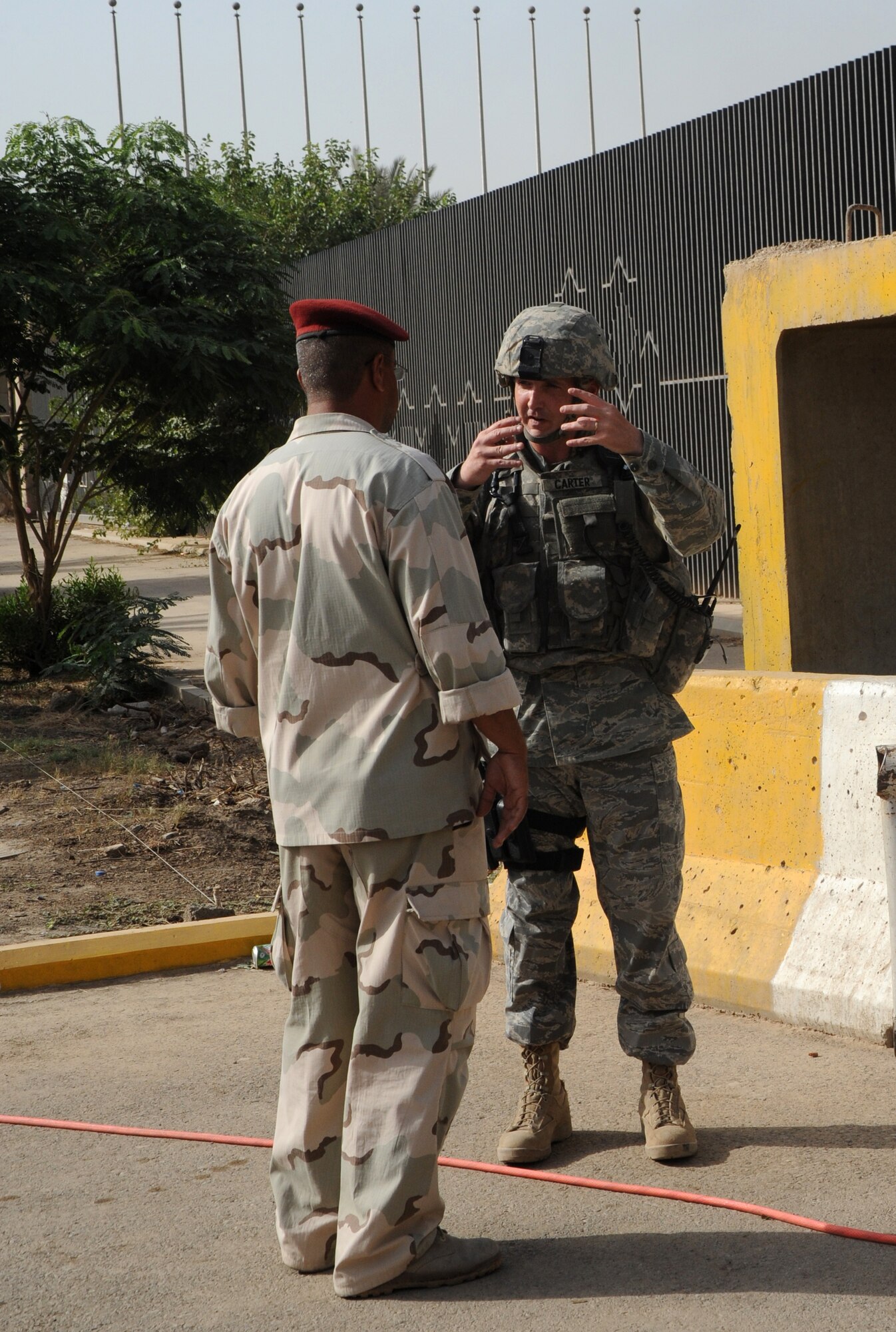 INTERNATIONAL ZONE,Baghdad, Iraq -- Tech. Sgt. John Carter, 732nd Expeditionary Security Forces Squadron, Detachment 4, talks with an Iraqi army soldier while responding to a call about an indirect fire point of impact on an Iraqi forward operating base within the International Zone May 28. (U.S. Air Force photo/Tech. Sgt. Amanda Callahan)