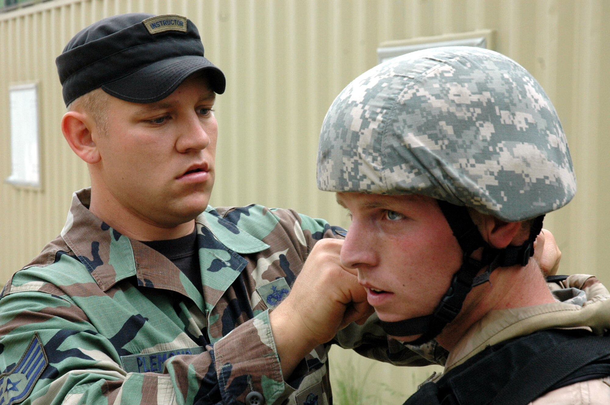 Staff Sgt. Luke Plemons, an instructor from the U.S. Air Force Expeditionary Center's 421st Combat Training Squadron of Fort Dix, N.J., assists a student in the Air Force Phoenix Warrior Training Course 08-5 with his helmet during training at Naval Air Engineering Station Lakehurst, N.J., June 5, 2008.  Phoenix Warrior is a course that prepares security forces Airmen for upcoming deployments.  (U.S. Air Force Photo/Staff Sgt. Paul R. Evans)