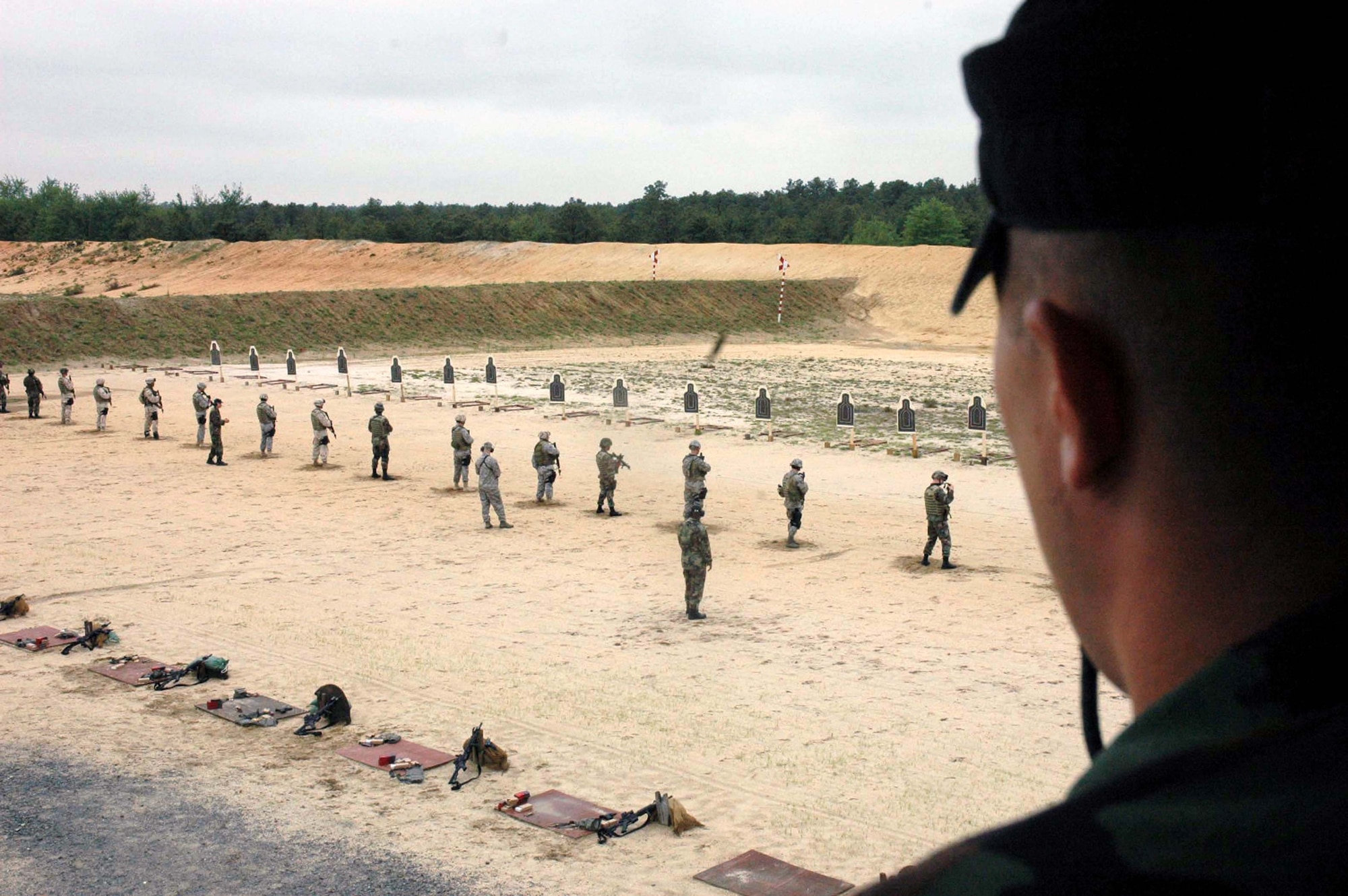 Staff Sgt. James Chubb, an instructor from the U.S. Air Force Expeditionary Center's 421st Combat Training Squadron watches students in the Air Force Phoenix Warrior Training Course 08-5 practice live-fire combat rifle training in a range on Fort Dix, N.J., June 5, 2008.  The course prepares security forces Airmen for upcoming deployments.  Annually, more than 23,000 students are trained at the USAF EC through in-residence and distance learning courses.  (U.S. Air Force Photo/Staff Sgt. Paul Evans)