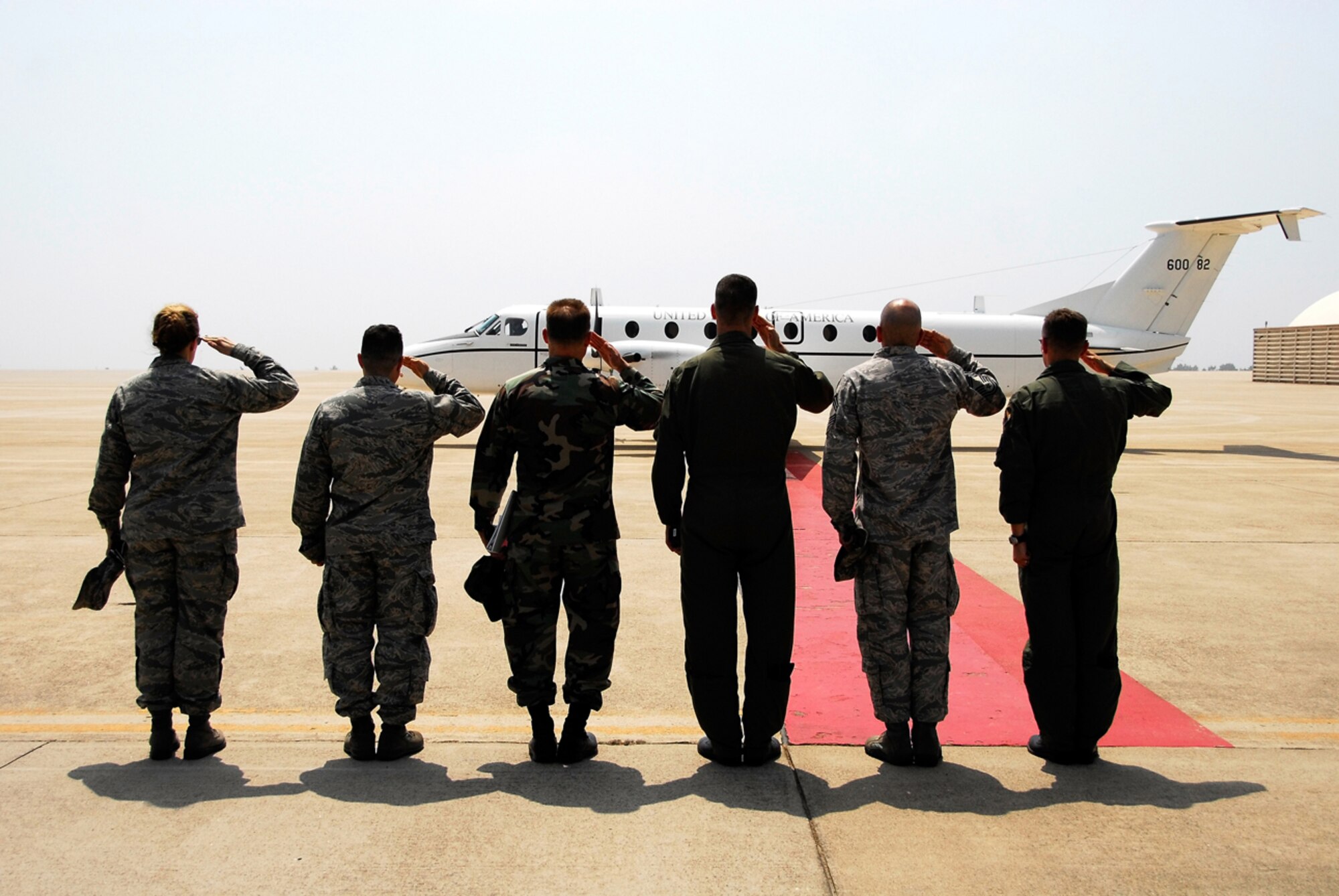 KUNSAN AIR BASE, Republic of Korea -- Colonels Rose Layman, Robert Nuanes, Michael Kucej, Pete Gersten, Chief Master Sergeant David Lewis and Col Bryan Bearden extend a salute to United States Forces Korea Commander General Walter Sharp as his plane departs here June 13.  Gen. Sharp recently took command of USFK and is visiting various areas throughout Korea.  (U.S. Air Force photo/Tech. Sgt. Quinton T. Burris) 