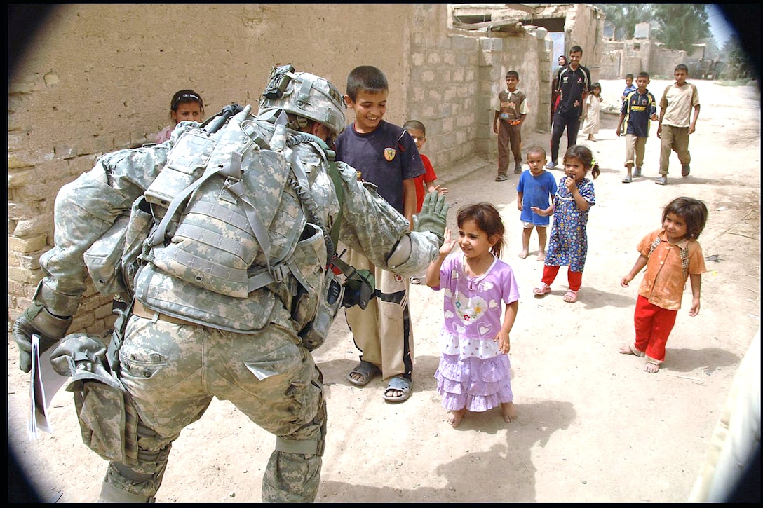 An Iraqi child gives a “high five” to a passing U.S. soldier from the 101st Airborne's 3rd Brigade Combat Team, which finished a meeting with the town's tribal leaders in Ludifiyah, Iraq, June 12, 2008.