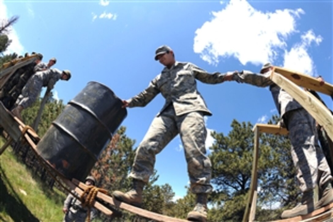 U.S. Air Force Airman 1st Class Phillip Baiao moves a barrel across an improvised bridge during a training exercise on Camp Rapid, Rapid City, S.D., June 9, 2008. The exercise tests the ability of engineering and support units to mobilize equipment, deploy to a battle zone, coordinate combat and service support missions, and re-deploy home. 