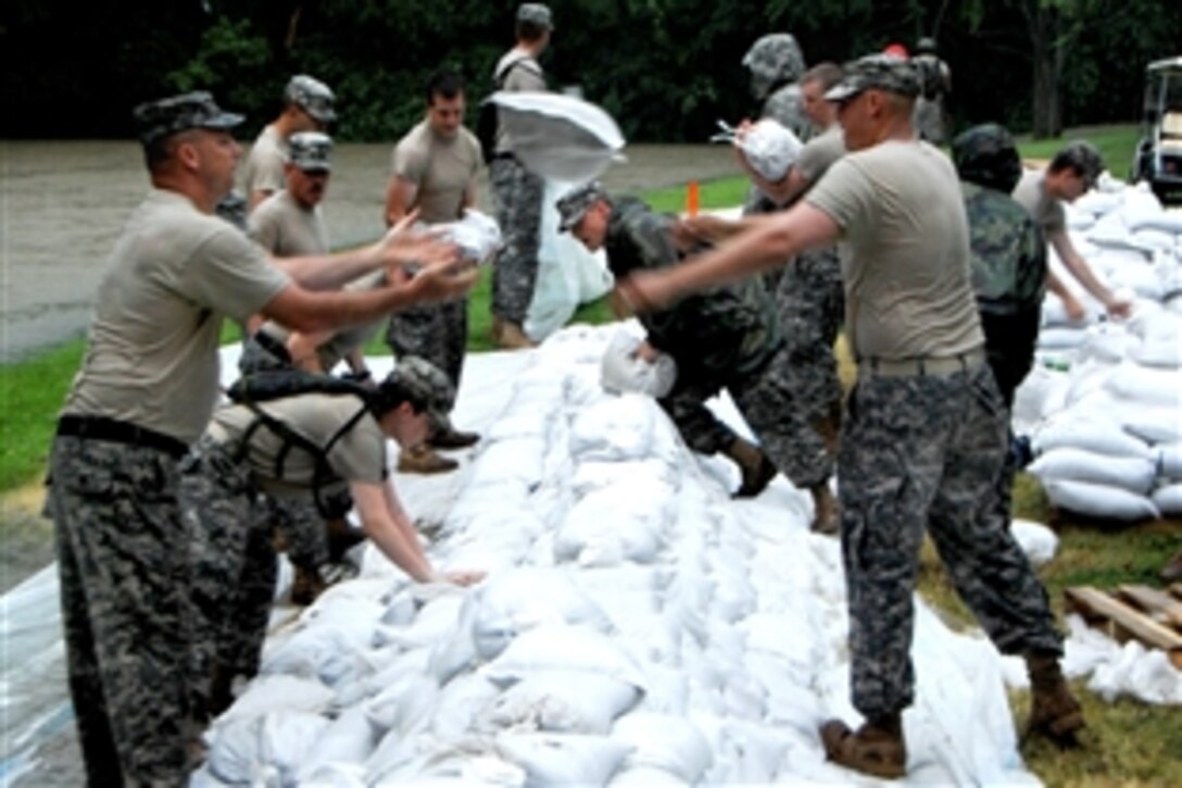 During a downpour, Indiana National Guard soldiers assigned to the 38th Infantry Division pack sandbags in the early morning hours on a levee along the Wabash River in New Harmony, Ind., June 13, 2008. 

