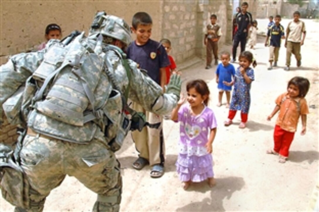 An Iraqi child gives a “high five” to a passing U.S. soldier from the 101st Airborne's 3rd Brigade Combat Team, which finished a meeting with the town's tribal leaders in Ludifiyah, Iraq, June 12, 2008. 