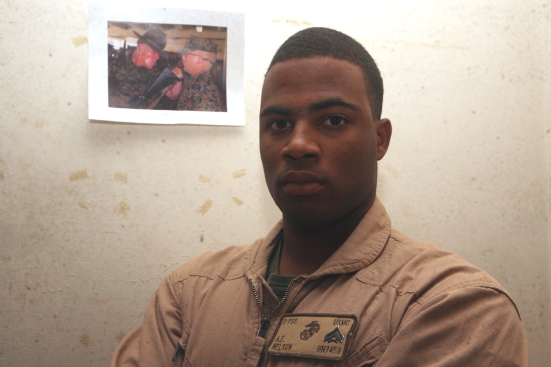 Cpl. Andrew E. Nelson, 21, a personnel clerk with 2nd Light Armored Reconnaissance Battalion, Regimental Combat Team 5, stands in front of a picture of his main goal, becoming a drill instructor, at Cam Korean Village, Iraq, June 15. Born in Philadelphia, Nelson overcame odds and struggling times to turn his life around.