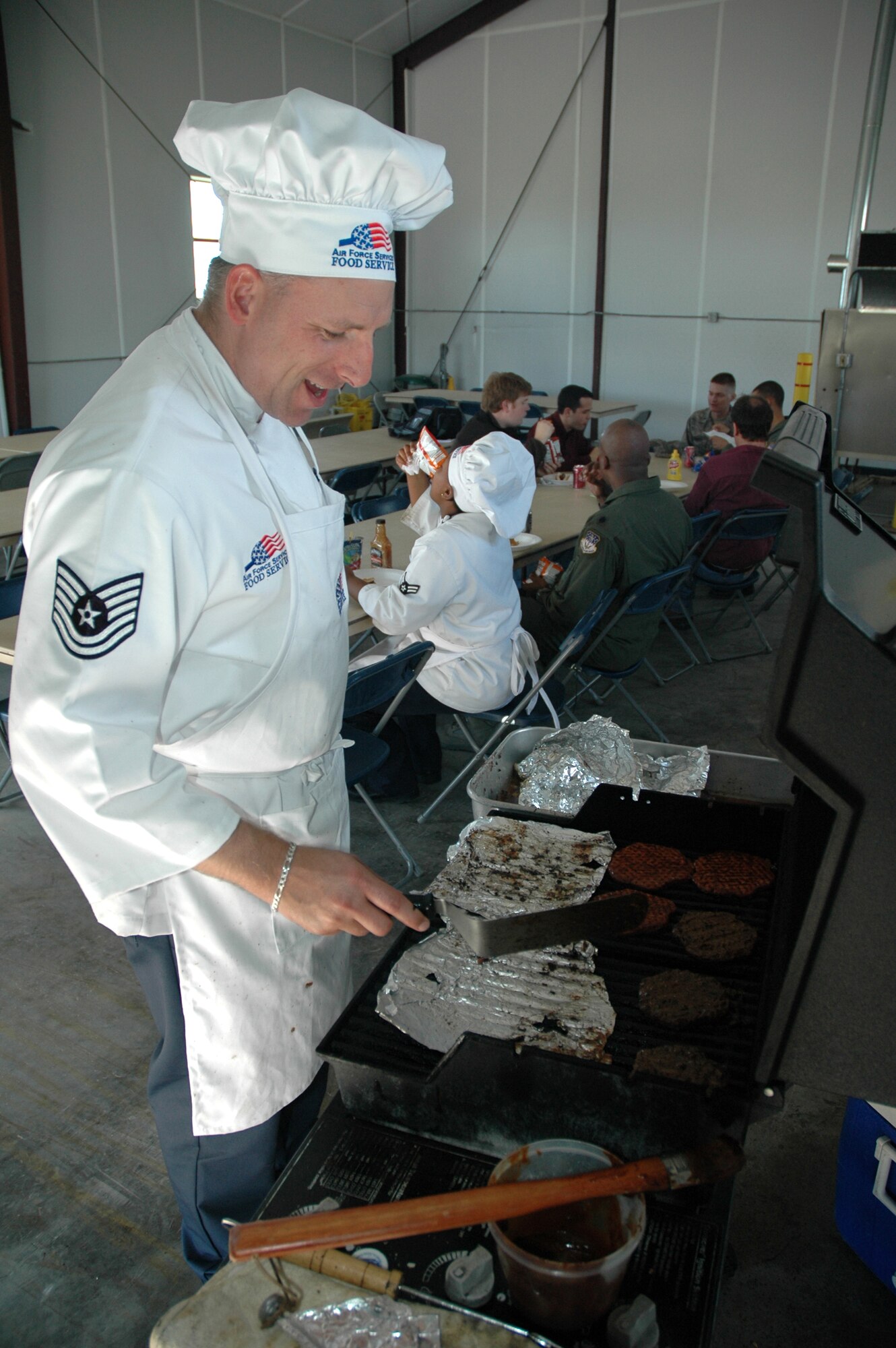 Tech. Sgt. Timothy Flud, 490th Missile Squadron missile chef NCO in charge, grills burgers during an open house for local elected officials and local news affiliates at Mike-01 June 13. (U.S. Air Force photo/Airman 1st Class Dillon White)