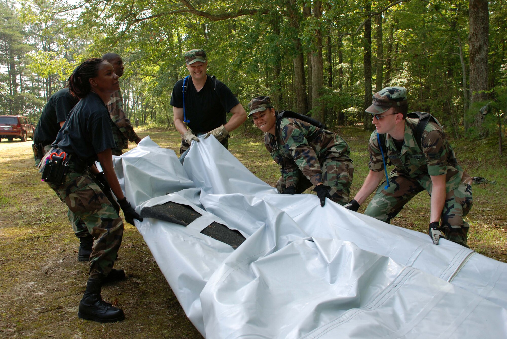 Members of the 459th Aeromedical Staging Squadron work along side members of the 69th Arial Port Squadron to breakdown "BRAVO" tent. The tent served as a simulated flightline for a group training exercise at Fort A.P. Hill, Va. Saturday. (U.S. Air Force photo/Senior Airman Ashley Crawford)