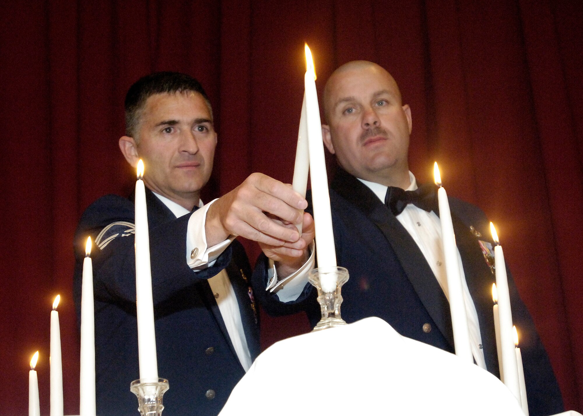 FAIRCHILD AIR FORCE BASE, Wash. – Senior Master Sgts. Michael Joyner, 92nd Maintenance Squadron, and Warren Scott, 92nd Aircraft Maintenance Squadron, light the final candle representing the rank of chief master sergeant during the Chief’s Recognition Ceremony at Club Fairchild June 13. (U.S. Air Force photo / Senior Airman Eunique Stevens)
