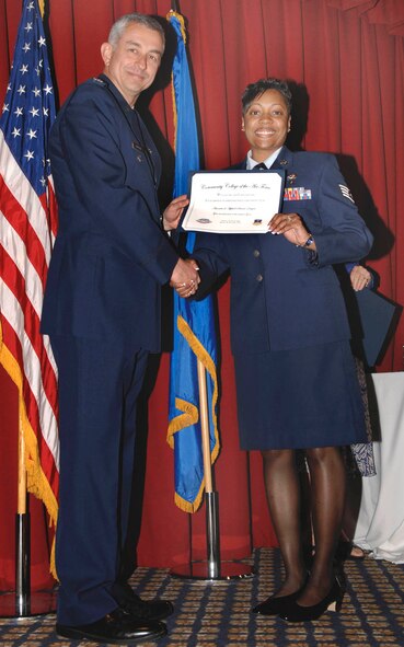 FAIRCHILD AIR FORCE BASE, Wash. – Col. Roger Watkins, 92nd Air Refueling Wing vice commander, presents  a  Community College of the Air Force degree to  Staff Sergeant Napasha Obermuller  at Club Fairchild June 13. (U.S. Air Force photo / Airman 1st Class Darlene West)