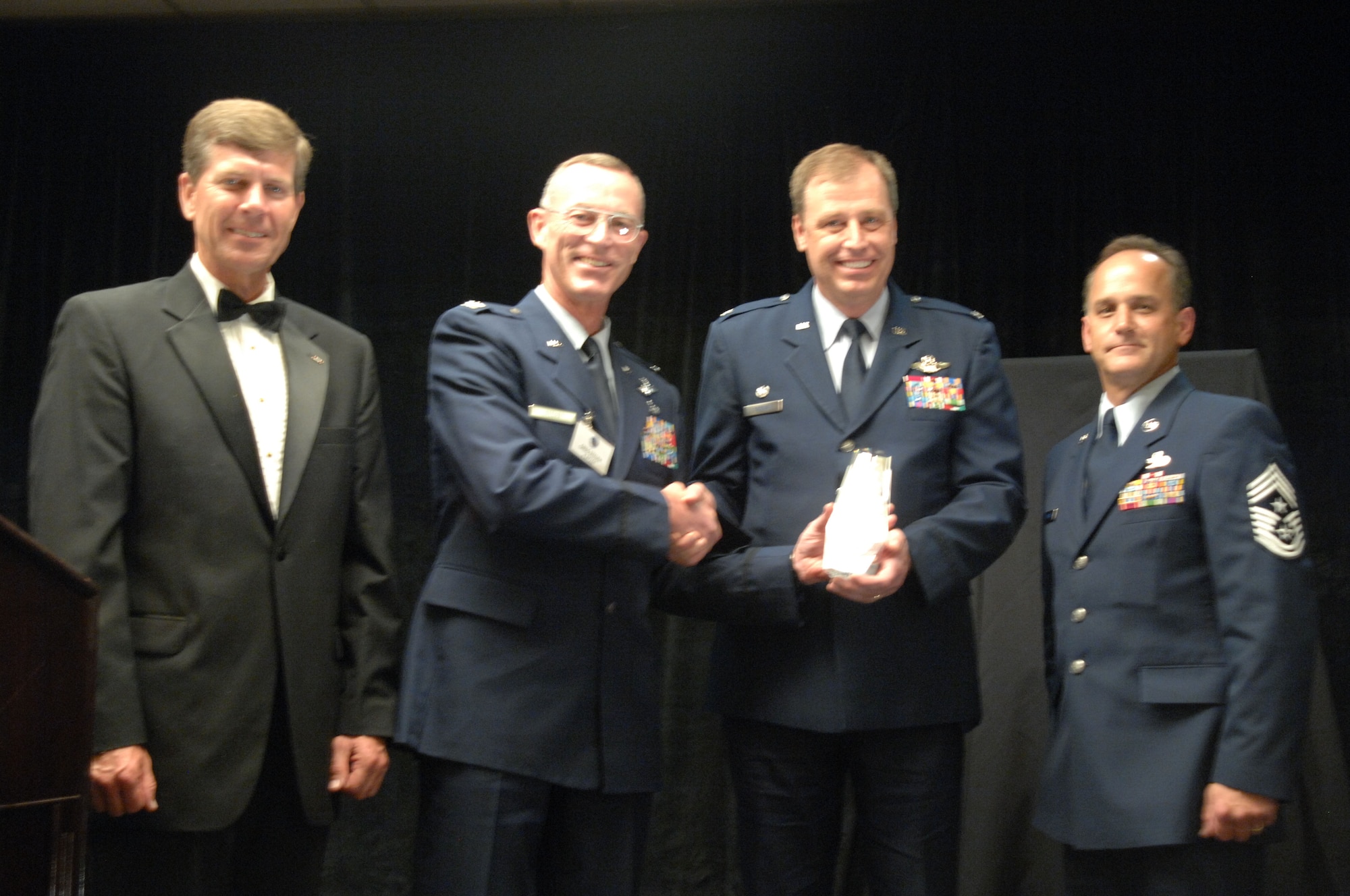 Mr. Harrison Hublein, Chair of the Riverside Military Affairs Committee, and Colonel Greg Steuer, Director of Logistics, Fourth Air Force, present the Chief Master Sergeant James Clouse Trophy to  Colonel Stephen Goeman and Command Chief Master Sergeant Aaron Mouser with the 445th Airlift Wing from Wright Patterson AFB, Ohio, during the 10th Annual Raincross Trophy Dinner held at the Riverside Convention Center in Riverside, California, on June 11, 2008.(USAF photo by Senior Master Sergeant Kim Allain)(released)