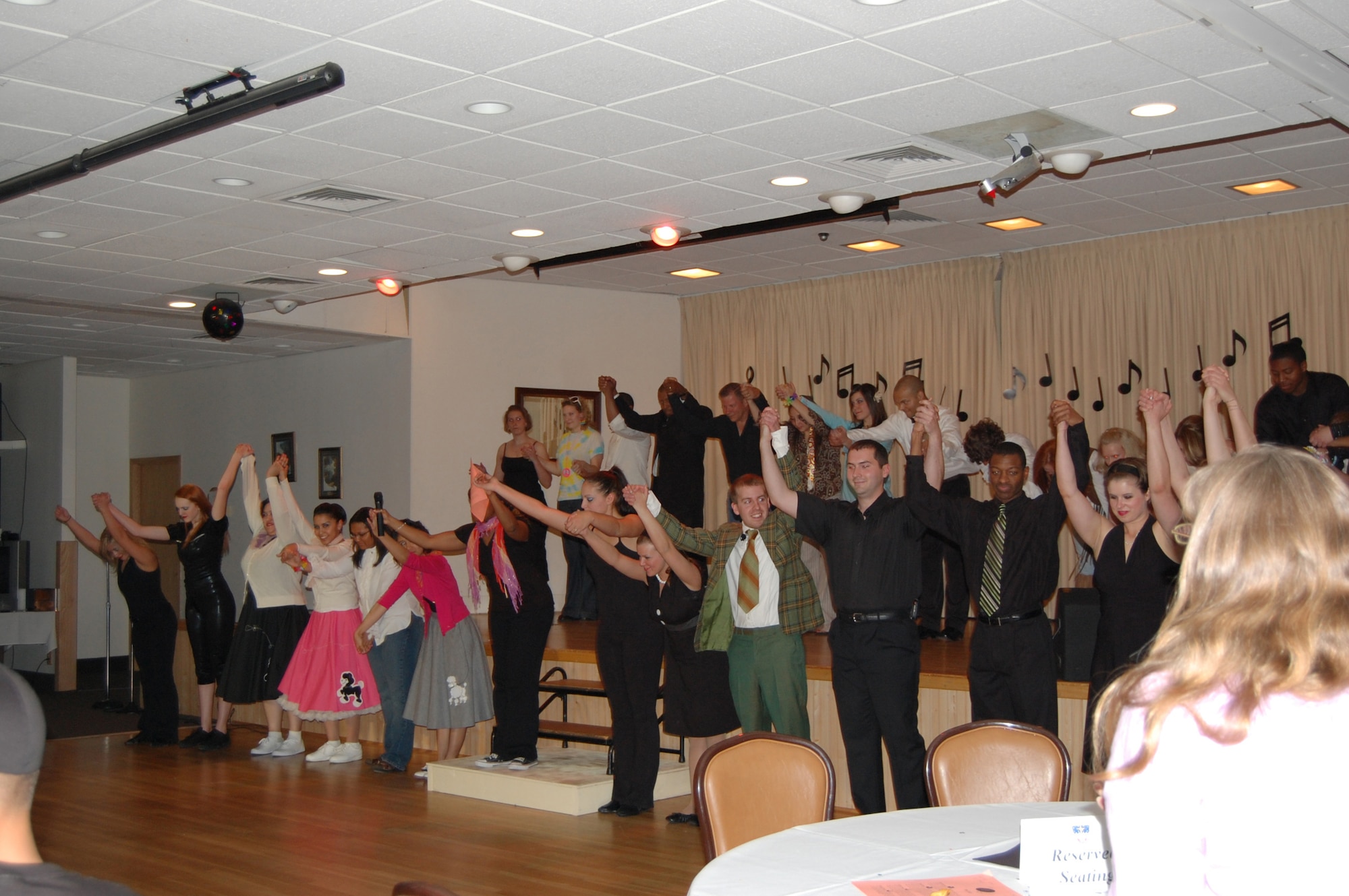Members of Wing It Theater take the stage after their performance June 14 to bow before the audience. Wing It performed an American Bandstand-like tribute at the Grizzly Bend Club June 14. (U.S. Air Force photo/Airman 1st Class Emerald Ralston)