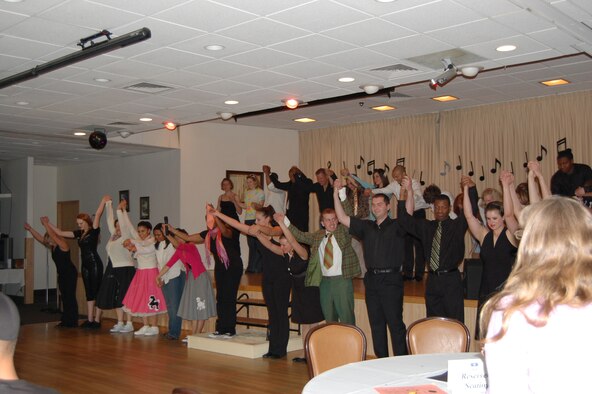Members of Wing It Theater take the stage after their performance June 14 to bow before the audience. Wing It performed an American Bandstand-like tribute at the Grizzly Bend Club June 14. (U.S. Air Force photo/Airman 1st Class Emerald Ralston)