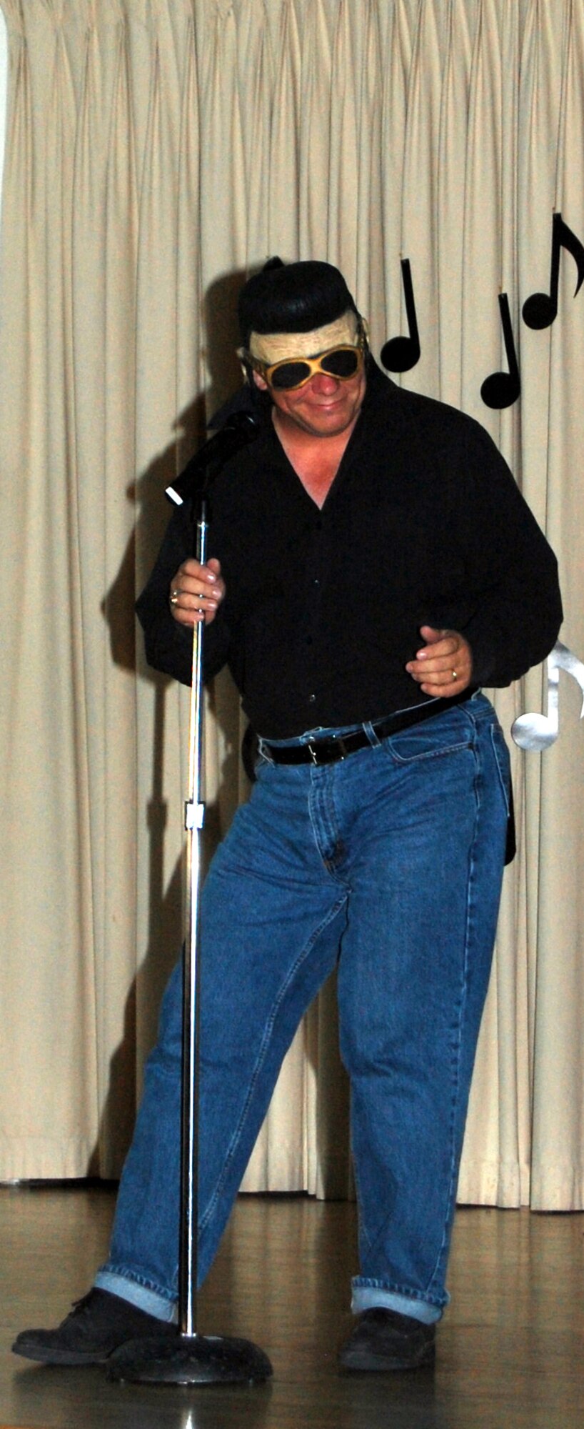 Chief Master Sgt. Steve Sargent, 341st Space Wing command chief, dons an Elvis wig and performs "Blue Suede Shoes" during the Wing It Theater American Bandstand-like tribute at the Grizzly Bend Club June 14. (U.S. Air Force photo/Airman 1st Class Emerald Ralston)
