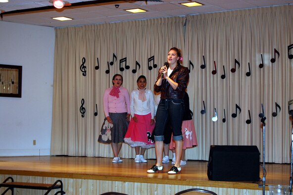 1st Lt. Naomi Haines, 12th Missile Squadron, performs "Leader of the Pack" at the Grizzly Bend Club June 14. Wing It Theater, Malmstrom's theater group, held an American Bandstand-like tribute that included military, family members and civilians singing and dancing to hits from the 1950s and 60s. (U.S. Air Force photo/Airman 1st Class Emerald Ralston)