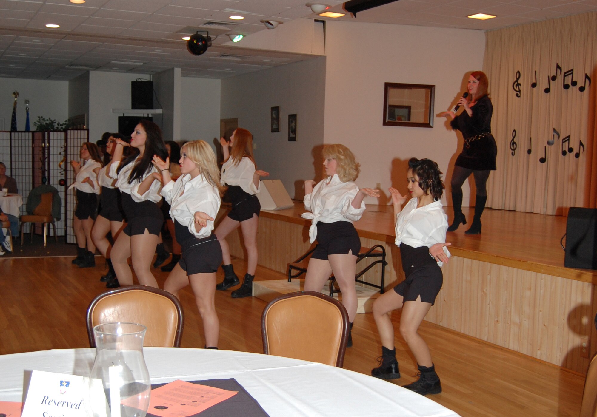Sue Bolbecker sings "These Boots Were Made for Walking" while other members of Wing It Theater, Malmstrom's theater group, dance. Wing It held an American Bandstand-like tribute at the Grizzly Bend Club June 14. (U.S. Air Force photo/Airman 1st Class Emerald Ralston)