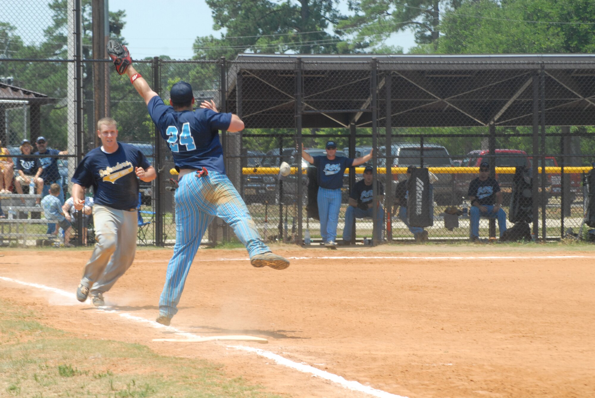 Ben Mooring, first baseman for the Joint Communications Unit, stretches off of the first base bag for a high throw while Adam Jessee, short stop for the 43rd Security Forces Squadron Defenders, tries to elude him during the Pope Intramural Softball Championship game June 13. (U.S. Air Force Photo by Irvin Gourdine)
