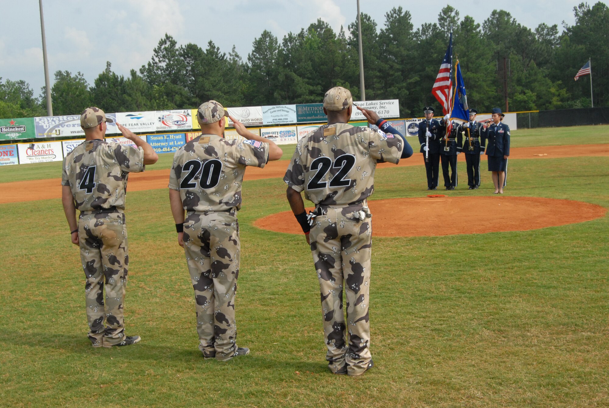 Air Force 2nd Lt. Jake Allen and Navy Aviation Electronics Technician Airman Blake Gerlikowski and Master Chief Petty Officer Elton Shaw, players for the U.S. Military All-Star Baseball Team, salute Staff Sgt. Marivic-Len Williamson and Pope’s Honor Guard during the National Anthem prior to the team’s game against the Fayetteville Swampdogs June 15. Sergeant Williamson and the Honor Guard were a portion of Pope’s contribution to the Swampdogs’ military appreciation weekend. (U.S. Air Force Photo by 2nd Lt. Chris Hoyler)
