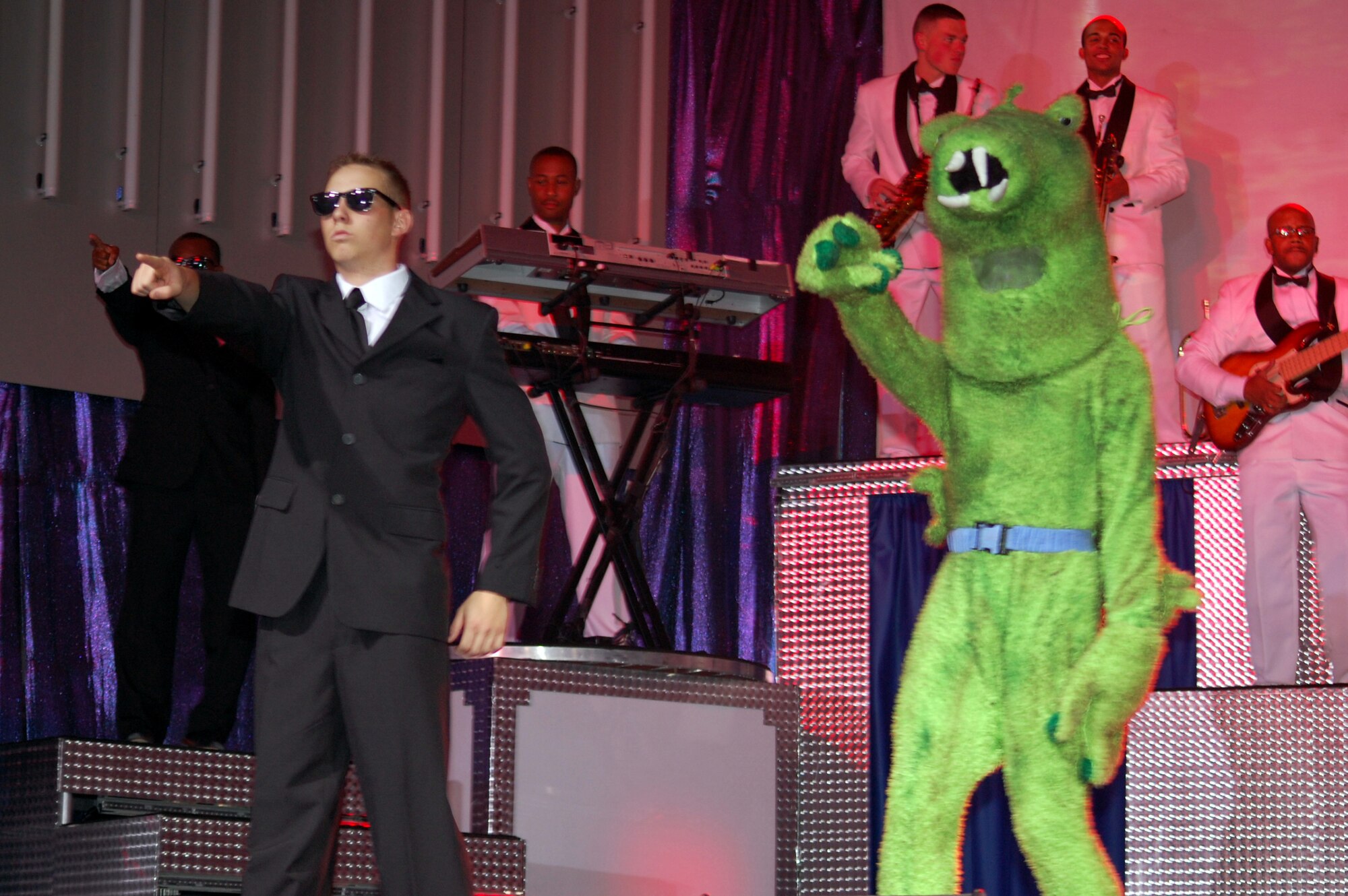 Airman 1st Class David Butler, readiness and emergency management apprentice with the 65th Civil Engineer Squadron, Lajes Field, Azores, performs with a Tops in Blue member dressed as an extraterrestrial during a performance of the "Men in Black" theme song. Tops in Blue performed at the Montana Expo Park June 15. (U.S. Air Force photo/Airman 1st Class Emerald Ralston)
