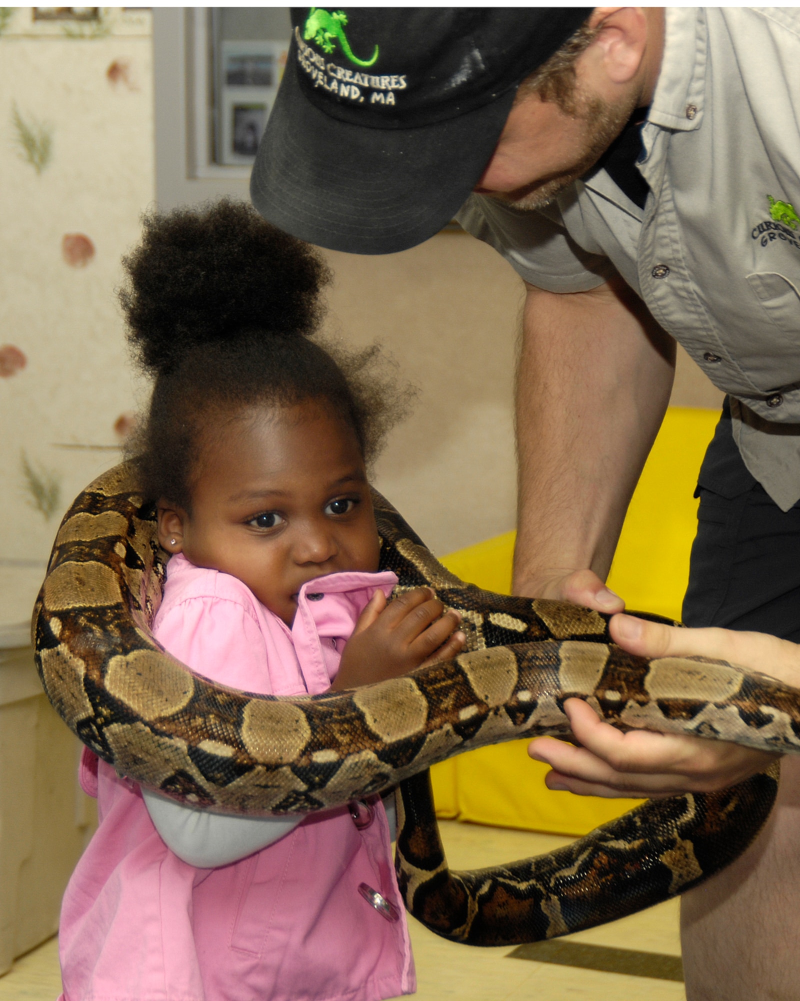 HANSCOM AFB, Mass. – Tahira Muhammed, gets a hug from a boa constrictor held by Doug Phinney from Curious Creatures on June 13 at the Child Development Center. Children had the opportunity to interact with and learn about mammals, amphibians, reptiles and arachnids during the Curious Creatures visit. (U.S. Air Force photo by Linda LaBonte Britt)