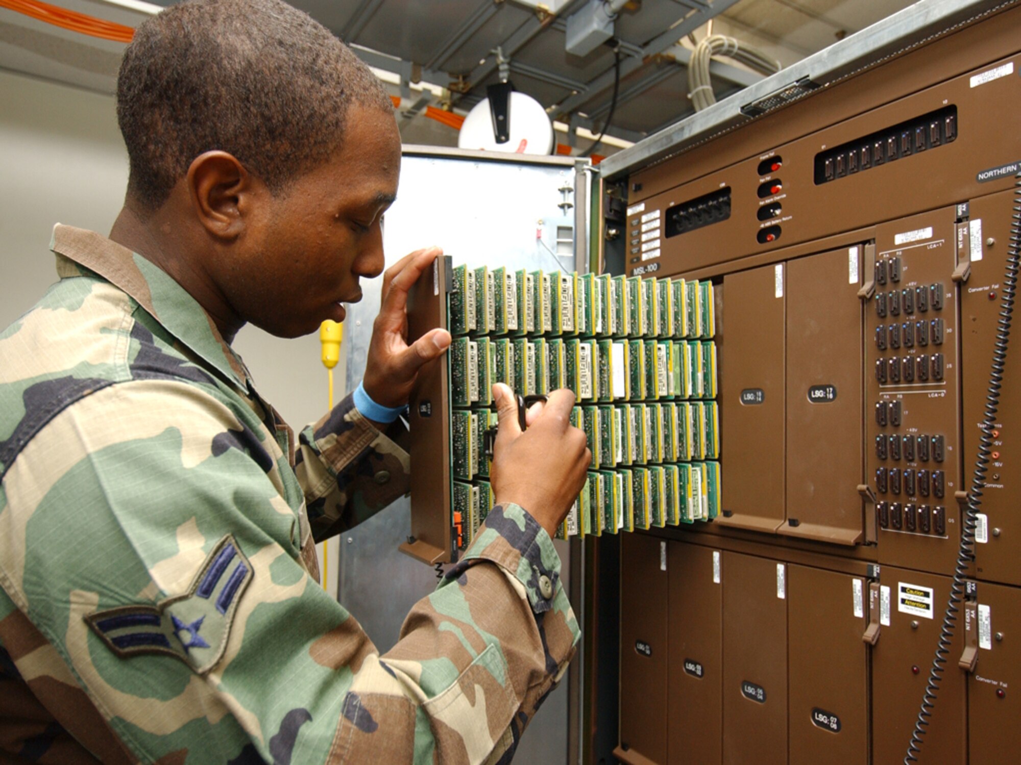 Left, Senior Airman Renard Jenkins, 81st Communications Squadron, changes out a single line phone line card.  (U.S. Air Force photo by Kemberly Groue)