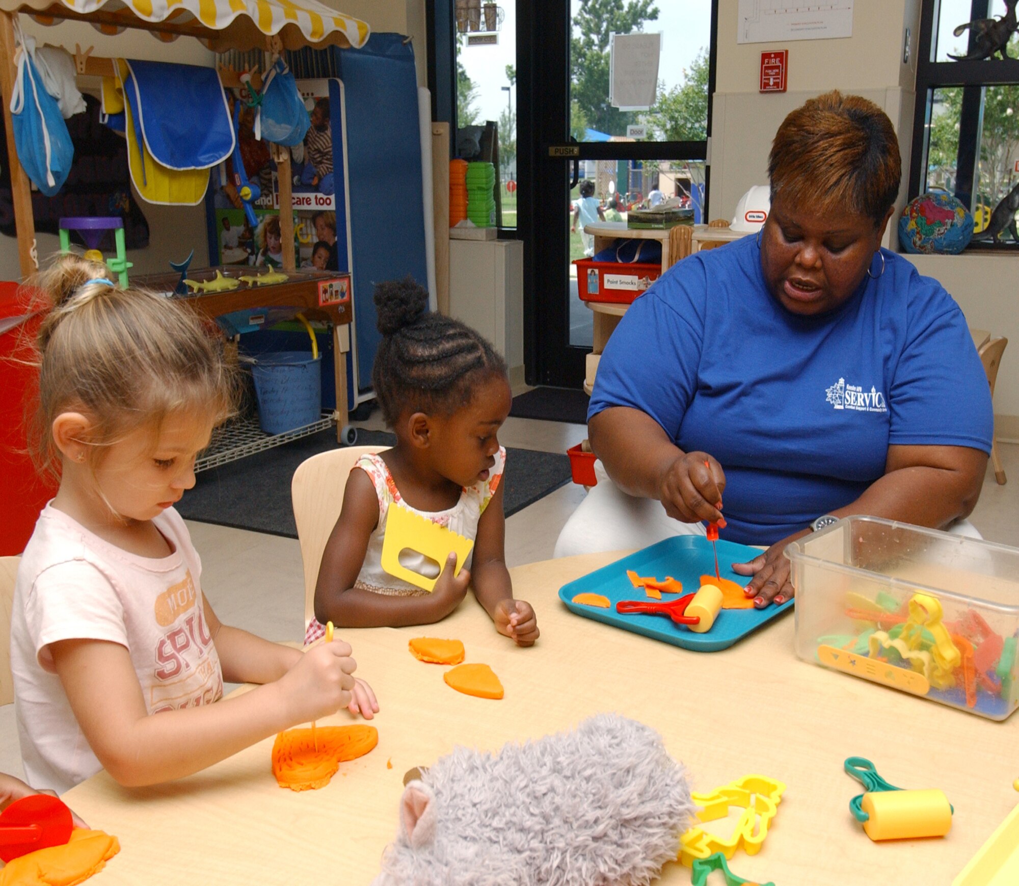 From left, Hannah Holmes, 5, and Zaria Bush, 4, make play dough shapes with Angela Gibson at the child development center.  Han-nah’s parents are Tech. Sgt. Michael Bangora, 334th Training Squadron, and Staff Sgt. Stephanie Ban-gora, 81st Medical Opera-tions Squadron.  Zaria’s parents are Brenda Bush, who works at the CDC, and Senior Airman Samuel Bush, 81st CS.  (U.S. Air Force photo by Kemberly Groue)