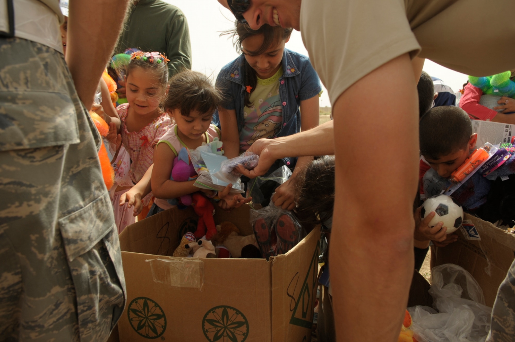 Members of the 447th Air Expeditionary Group pass out toys and gifts donated by the Airmen June 6 at Sather Air Base, Iraq. The gifts were donated and delivered as part of the Good Neighbor Program at Sather AB. (U.S. Air Force photo/Tech. Sgt. Jeffrey Allen)