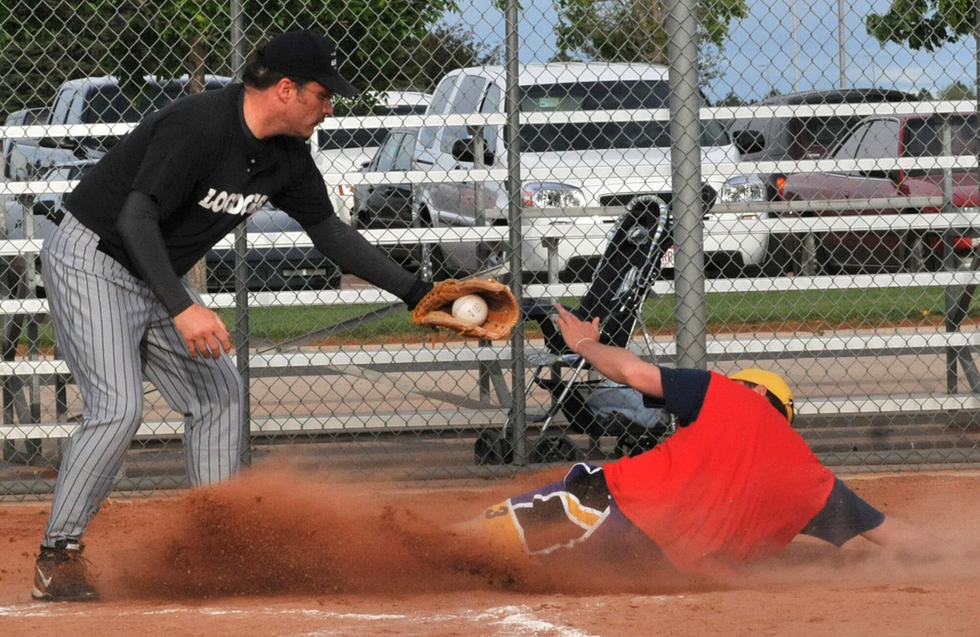 Team Colorado’s Dan Pocius, right, scores a run for his team during intramural softball action June 12 at the Peterson Air Force Base Fitness and Sports softball complex, located in Colorado. (CSMNG photo/Walt Johnson)