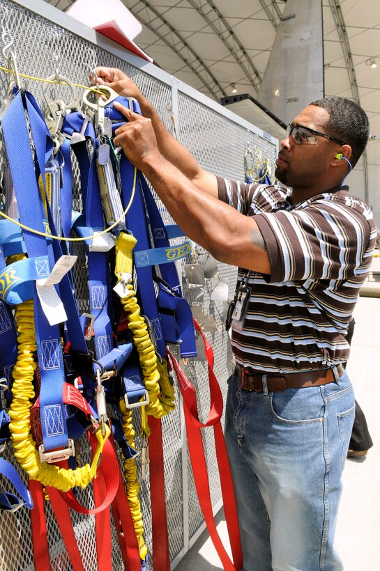 Maurice Appling hangs safety harnesses for aircraft mechanics use at Warner Robins Air Logistics Center, Ga. Mr. Appling manages a cart close to the aircraft with support equipment that is readily available to the mechanics, cutting down the time they must spend away from the aircraft. Mr. Applping is a supply technician. (U. S. Air Force photo/Sue Sapp) 