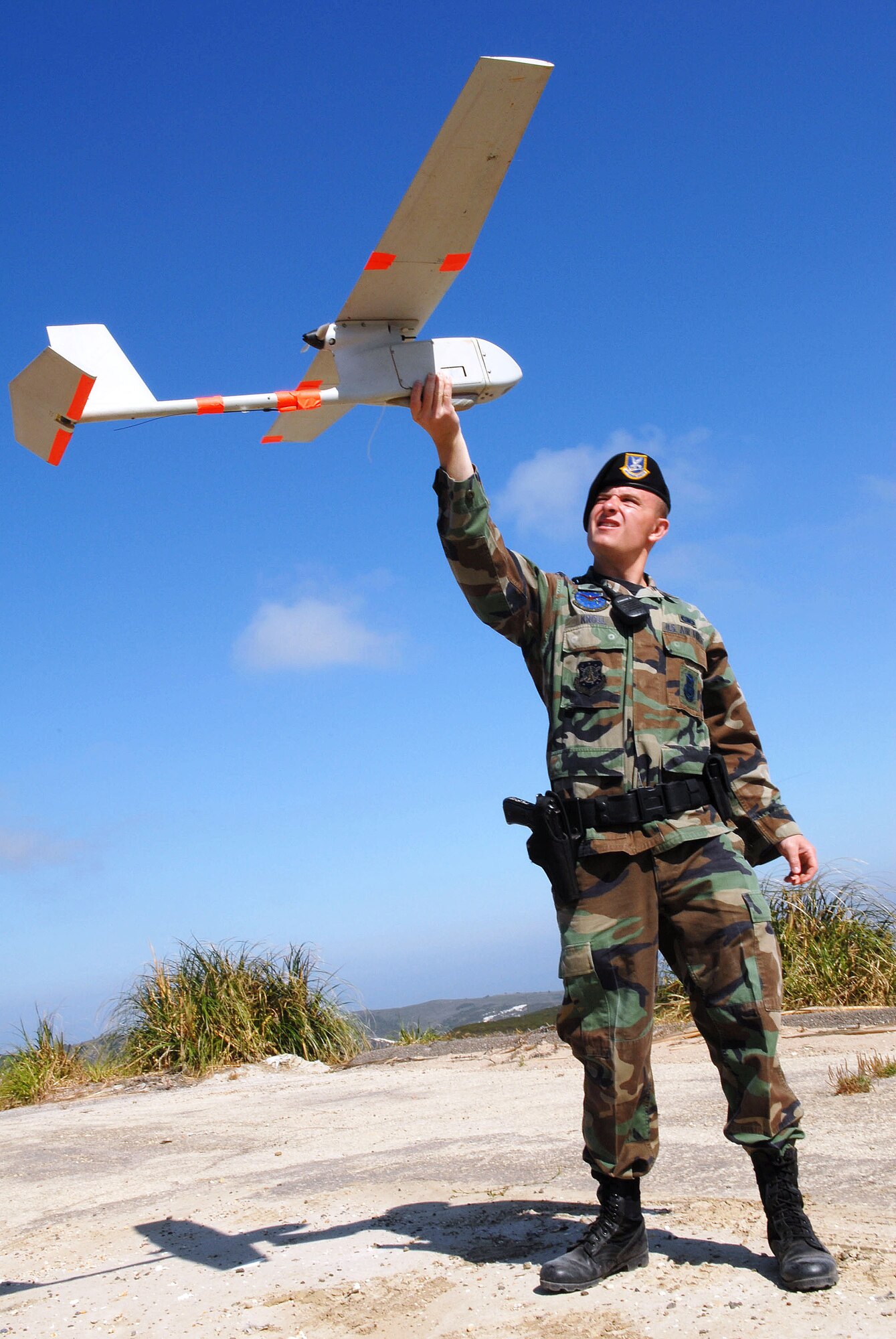 VANDENBERG AIR FORCE BASE, Calif --  Airman 1st Class Jeff Knoll, 30th Security Forces Squadron, does a pre-flight check of the Raven, Vandenberg's un-manned aerial vehicle.The Raven weighs 4.5 pounds, has a five-foot wingspan and stretches only 38 inches in length. The Raven is equipped with an video camera which streams live feed to an operator on the ground. (U.S. Air Force photo / Senior Airman Erica Stewart)
