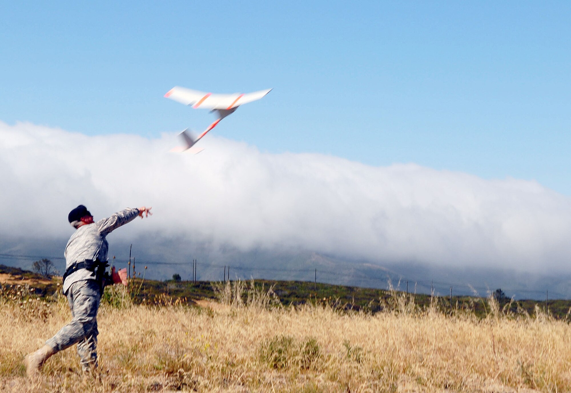 VANDENBERG AIR FORCE BASE, Calif. --  Tech. Sgt. Troy Simchak, 30th Security Forces Squadron, hand-launches the 30th SFS's unmanned areial vehicle. The Raven weighs 4.5 pounds, has a five-foot wingspan and stretches only 38 inches in length. The Raven is equipped with a video camera which streams live feed to an operator on the ground. (U.S. Air Force photo / Senior Airman Erica Stewart) 