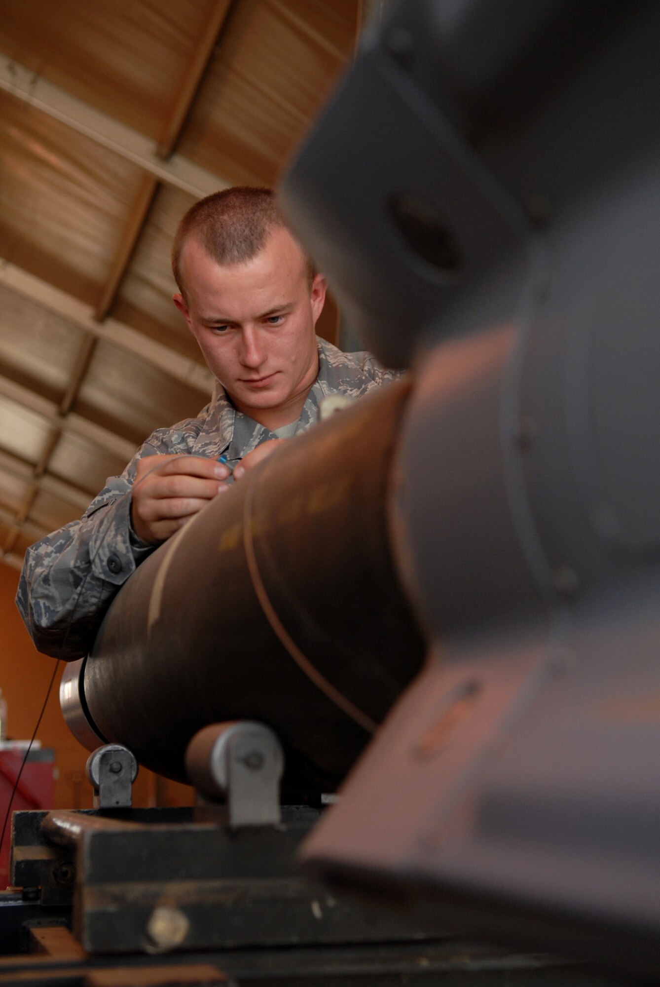 Airman 1st Class Richard Spurgeon connects a guided bomb unit-12 arming lanyard to a bomb body June 16 at Joint Base Balad, Iraq. The length of the lanyard is determined based upon on the aircraft it will be attached to. This lanyard controls the initiation timing according to the aircraft specifications; the GBU-12 can self-guide to a target pinpointed by a laser designator, which helps to minimize collateral damage resulting from detonation. Airman Spurgeon is a 332nd Expeditionary Maintenance Squadron munitions systems specialist deployed from Shaw Air Force Base, S.C. (U.S. Air Force photo/Senior Airman Julianne Showalter) 