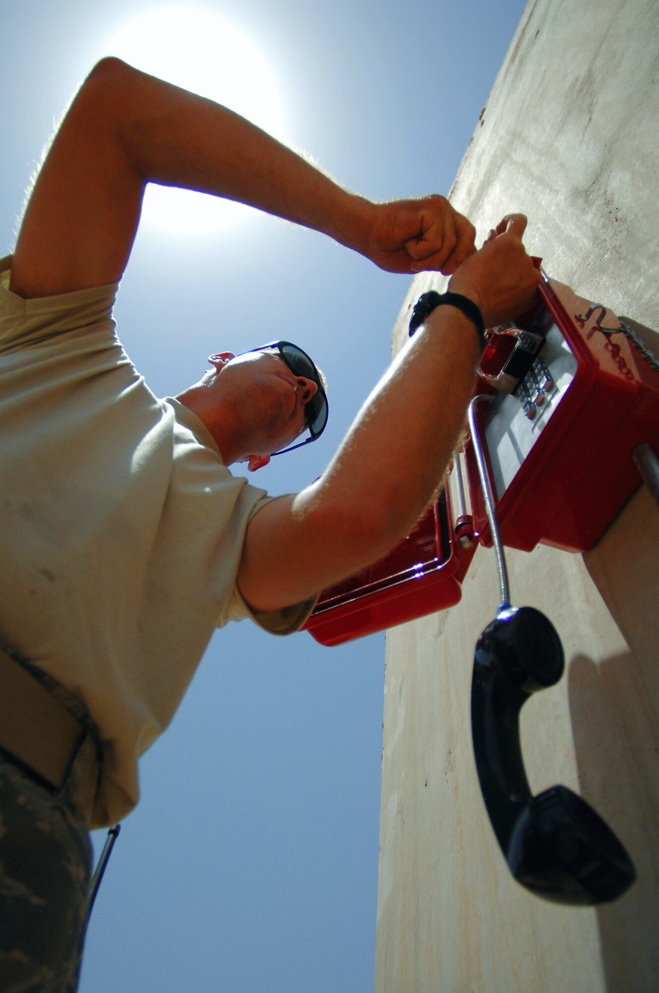Staff Sgt. Phillip Balson mounts a new weather-resistant emergency phone on a T-barrier in the Air Force housing area June 13 at Balad Air Base, Iraq. More than 120 lines were installed throughout the housing area so servicemembers can give notice during accountability checks. Sergeant Balson is a 332nd Expeditionary Communications Squadron infrastructure technician deployed from Tinker Air Force Base, Okla. (U.S. Air Force photo/Senior Airman Julianne Showalter) 
