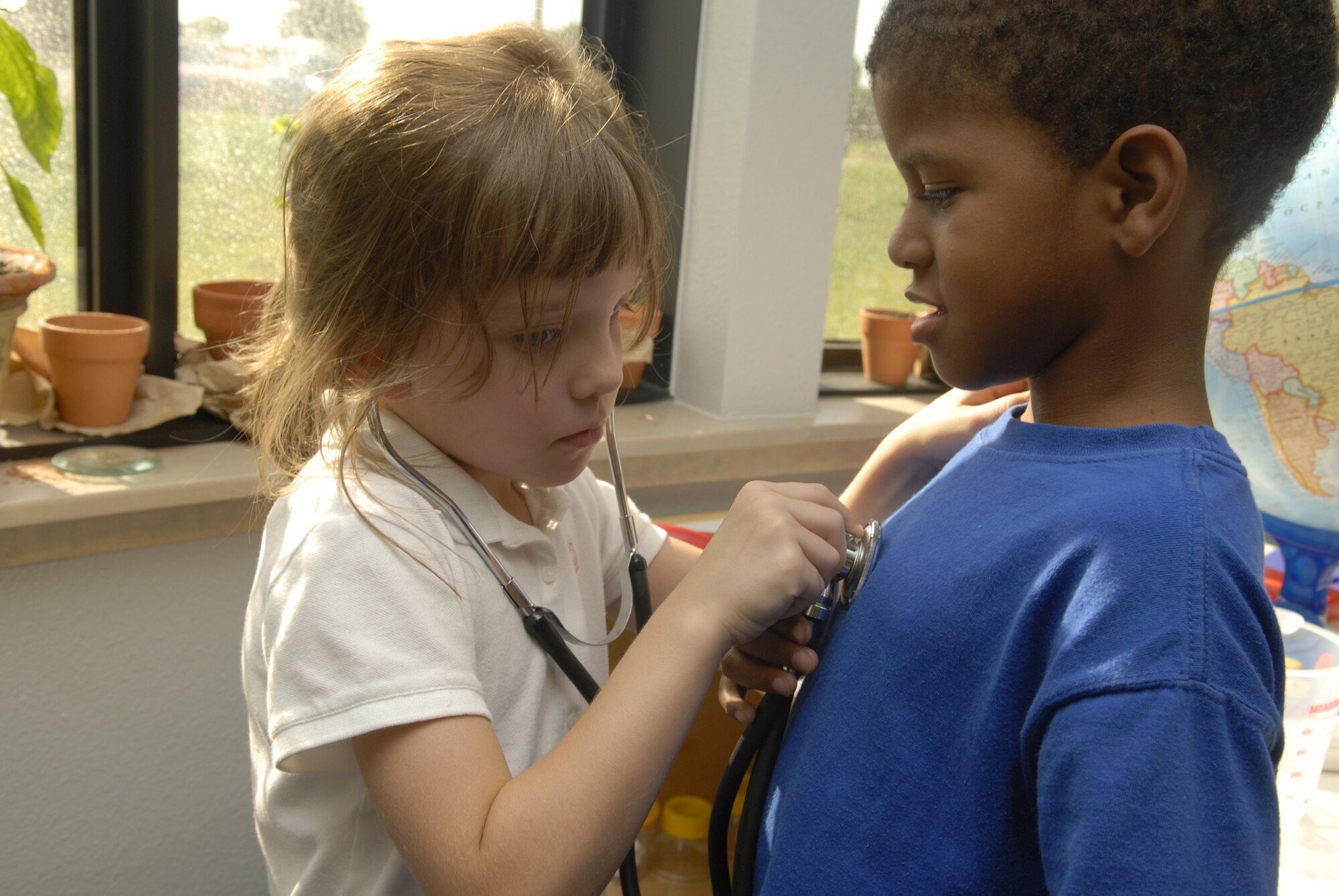 Five-year-old Nisa McKenzie and six-year-old Malik Finley experiment with the toys available to the children at the school-age faciility. The classrooms are equipped with various educational tools such as books, building blocks, microscopes, maps, and various types of plants. (U.S. Air Force photo by Senior Airman Kamaile Chan)